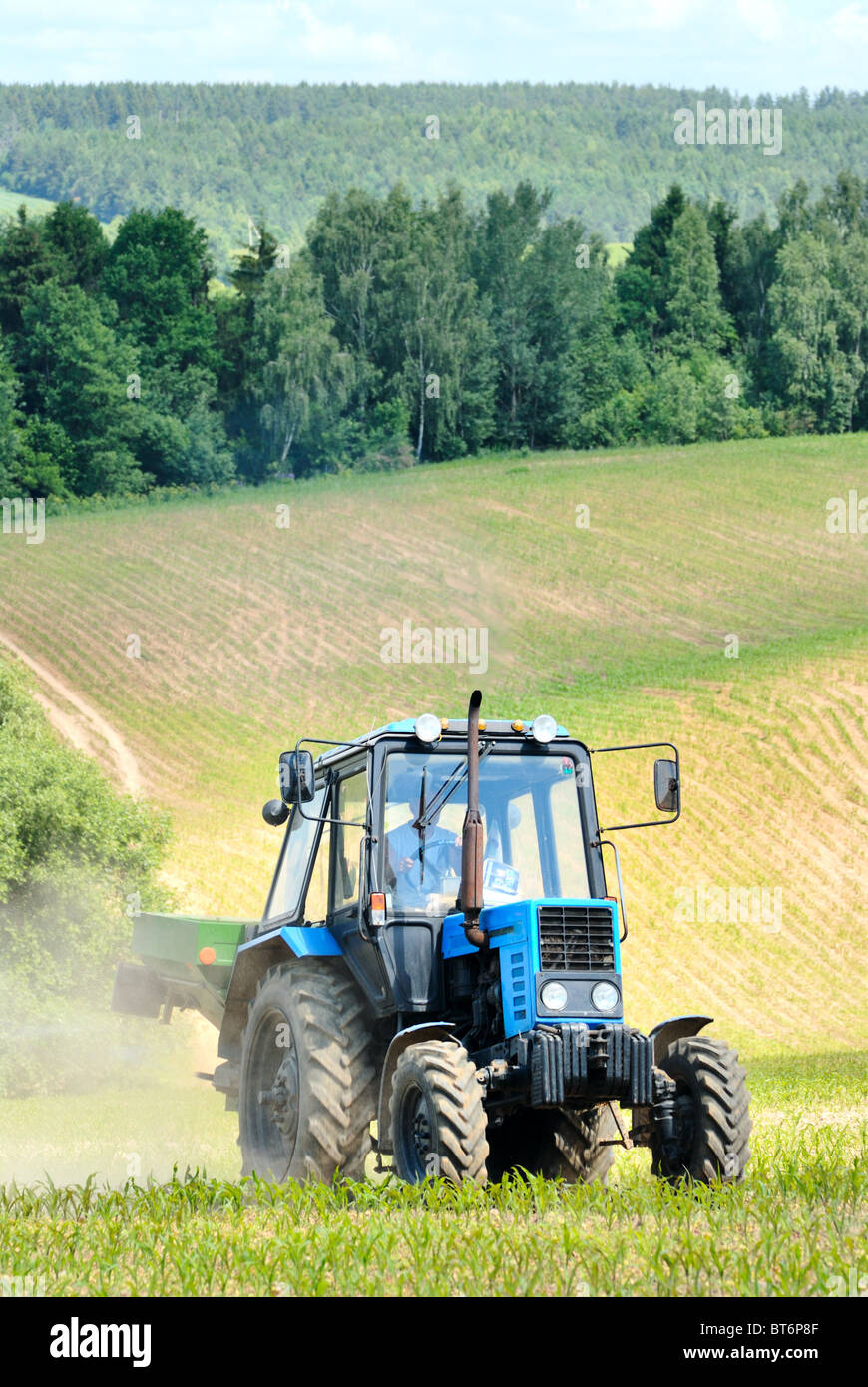 Le tracteur dans un champ au début de l'été Banque D'Images