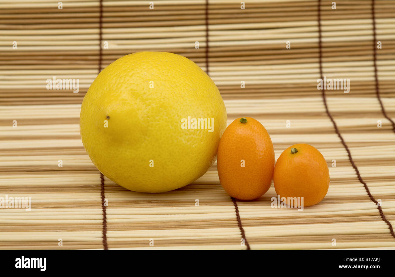 Citron jaune et orange sur le tapis en bois kumquat Banque D'Images