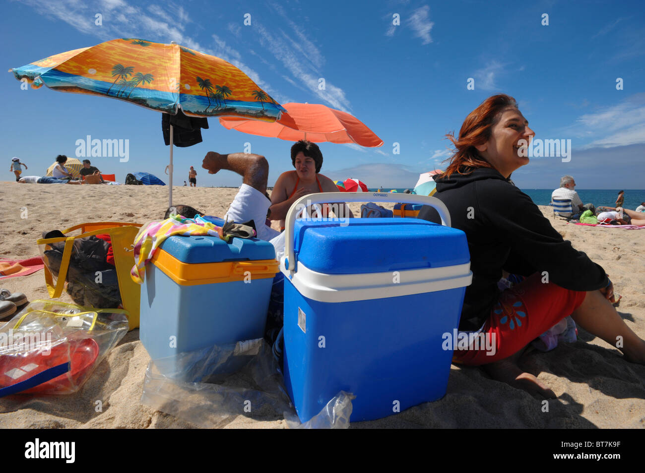 Famille avec refroidisseurs portables colorés et des parasols de plage de Figueira da Foz au Portugal Banque D'Images