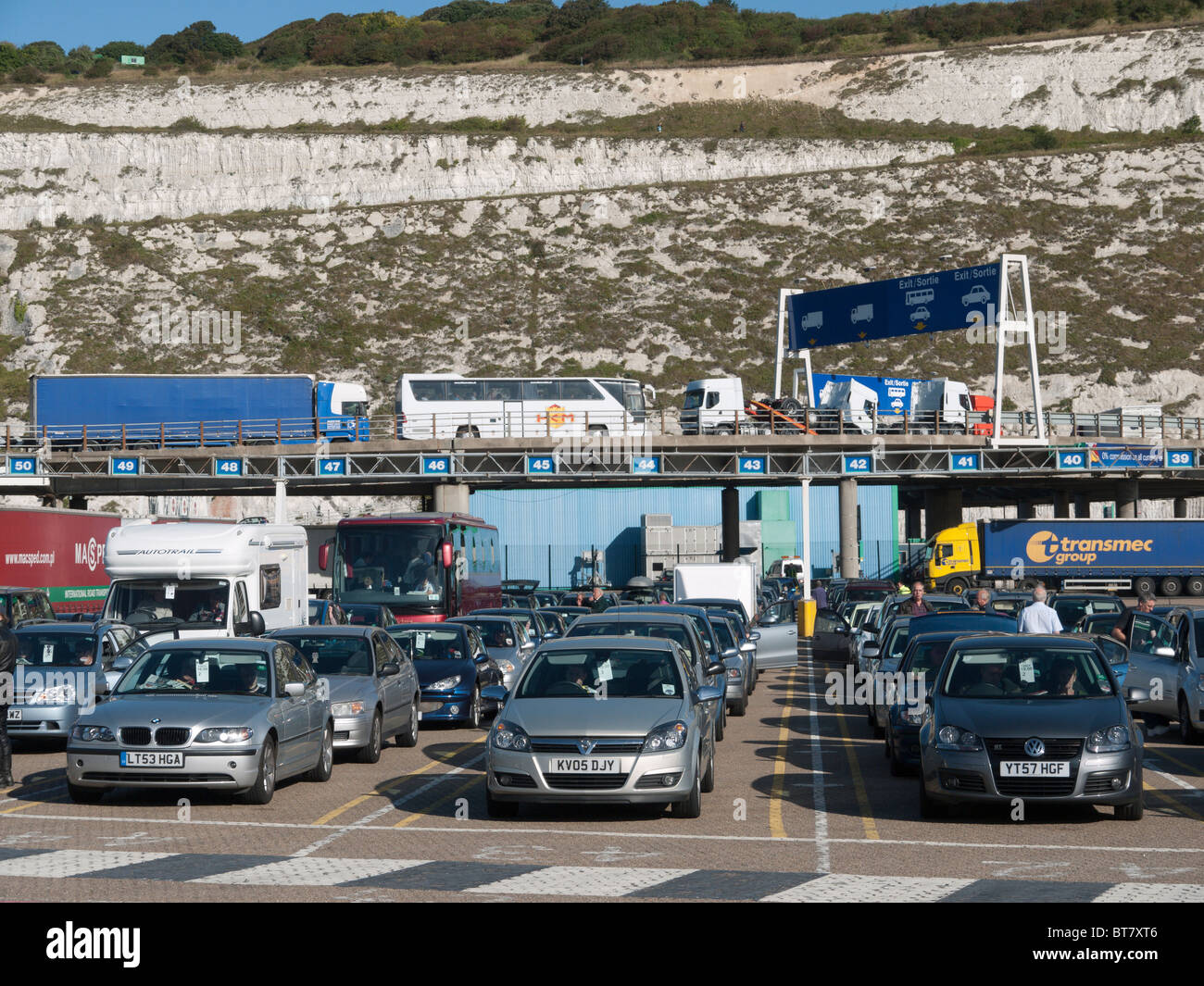 Des voitures font la queue à bord dans le port de ferries de Douvres comme camions arrivant quitte le docks Banque D'Images