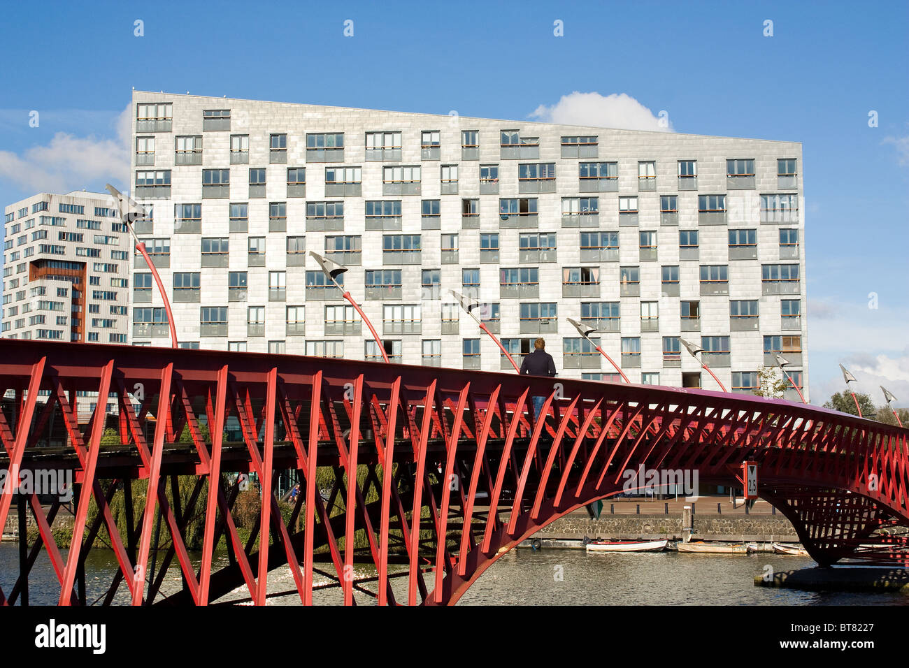 L'architecture moderne : pont en acier rouge à Amsterdam, Eastern Docklands Sfinx building en arrière-plan, par Frits van Dongen Banque D'Images