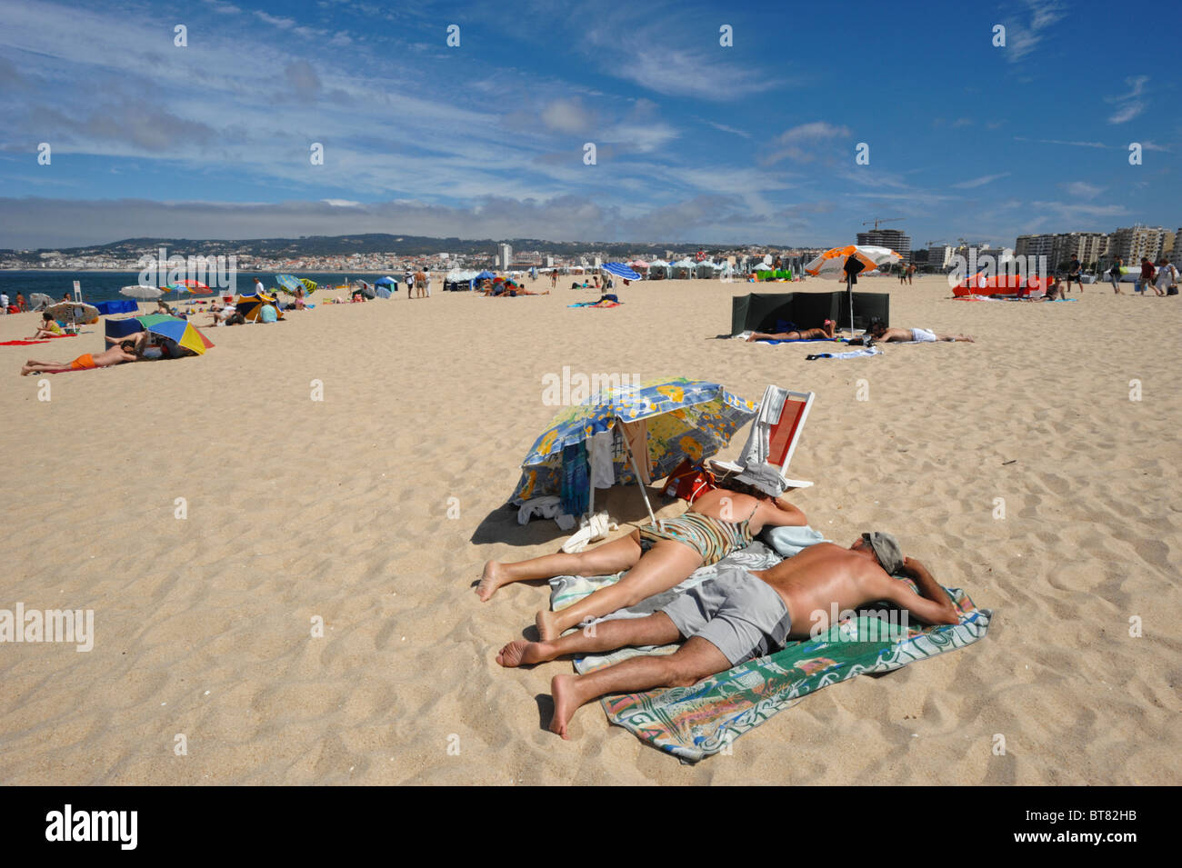 Deux personnes âgées à bronzer sur le sable plage de Figueira da Foz, Portugal Banque D'Images