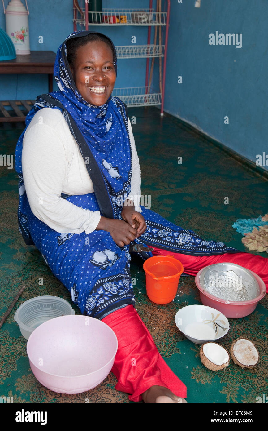Jambiani, Zanzibar, Tanzanie. Femme faisant le lait de coco. Elle porte un nez-pin dans sa narine gauche. Banque D'Images