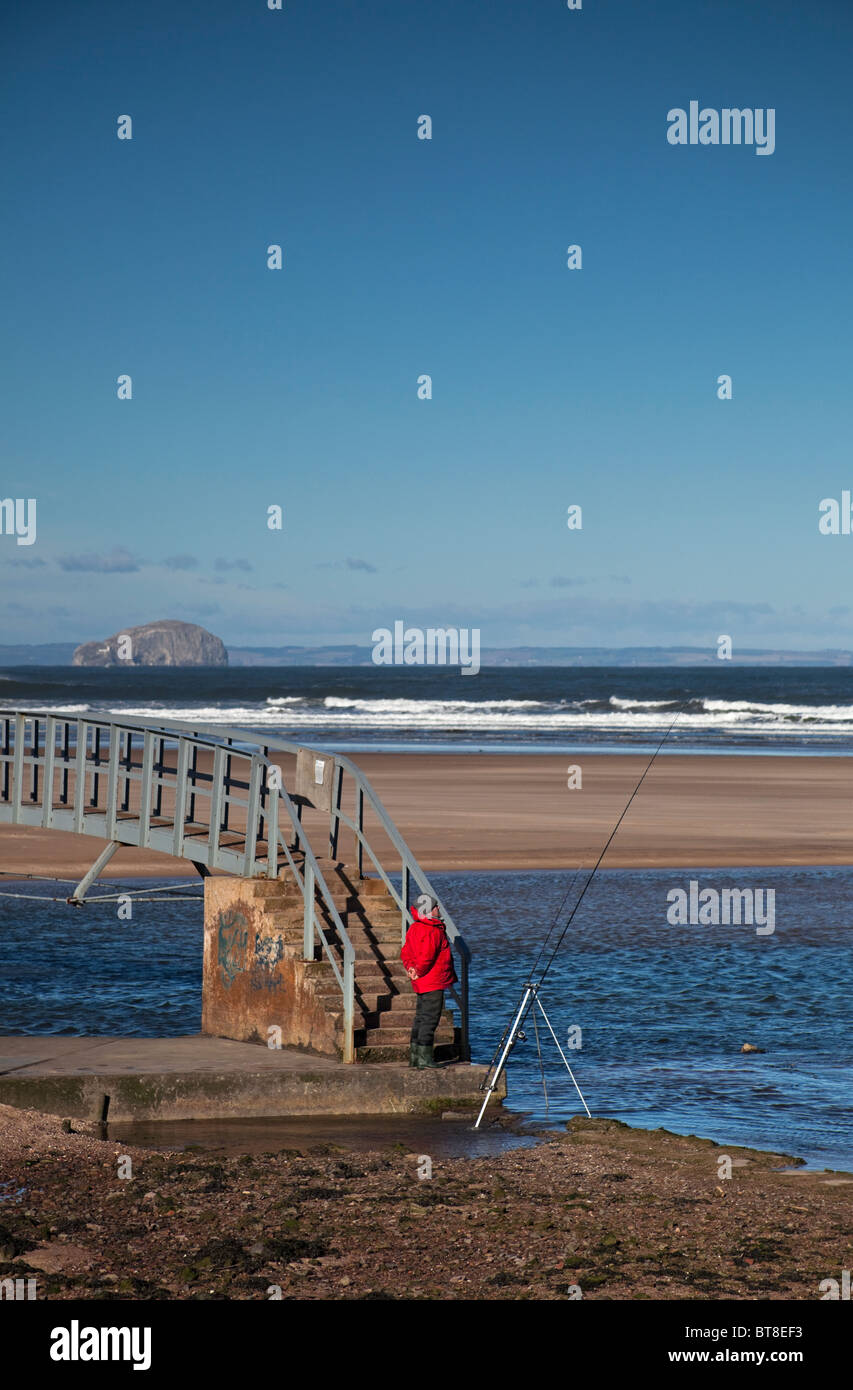 L'homme pêche en mer Belhaven Bay Beach, East Lothian en Écosse, Royaume-Uni, Europe Banque D'Images
