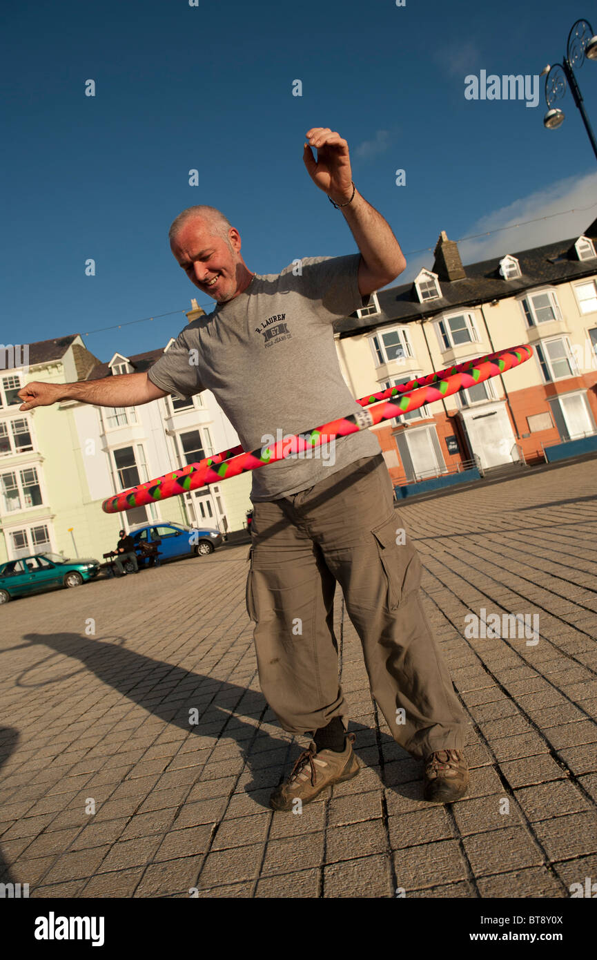 Un étudiant de l'université d'Aberystwyth en utilisant hoolah hulah hula hoops en plein air, UK Banque D'Images