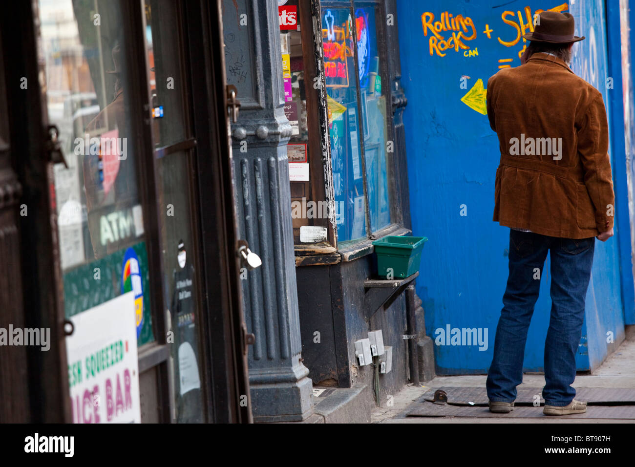 L'homme l'utilisation d'un cellulaire dans l'East Village, Manhattan, New York Banque D'Images