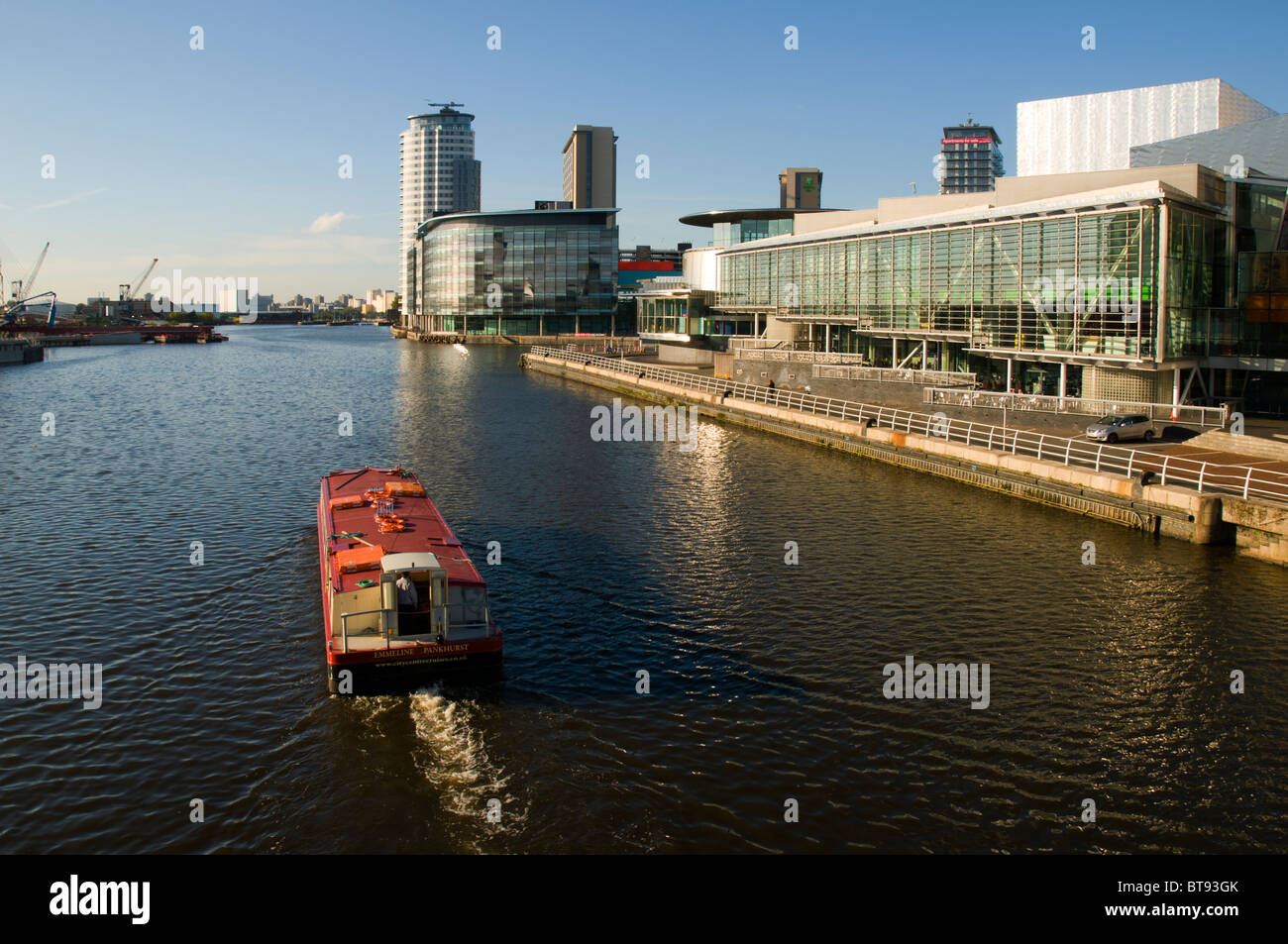 Un bateau d'excursion en passant le Lowry Centre à Salford Quays, Manchester, Angleterre, Royaume-Uni. Le complexe MediaCityUK derrière. Banque D'Images