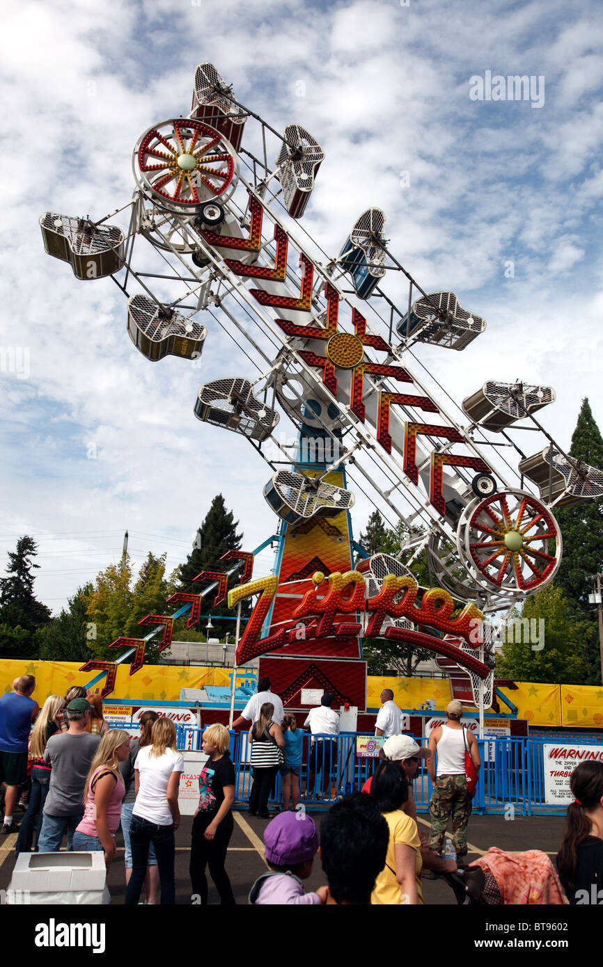 A Carnival ride tourne autour de ses coureurs comme clients pour leur propre tour à la tête de tourner l'amusement. Banque D'Images