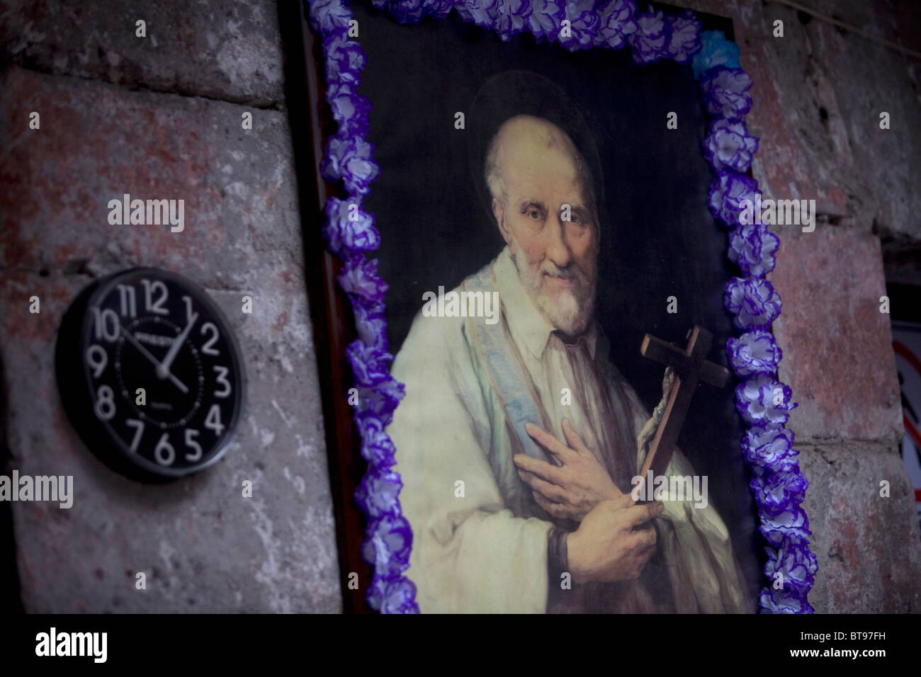 Une horloge murale et une peinture de Saint Vincent de Paul est affiché dans Notre Dame de Guadalupe Accueil pour les personnes âgées, la ville de Mexico Banque D'Images