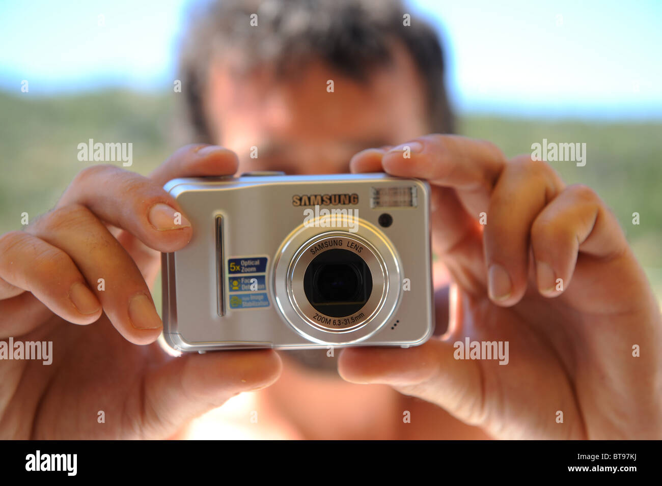 Man taking photo avec appareil photo numérique Samsung en vacances Banque D'Images