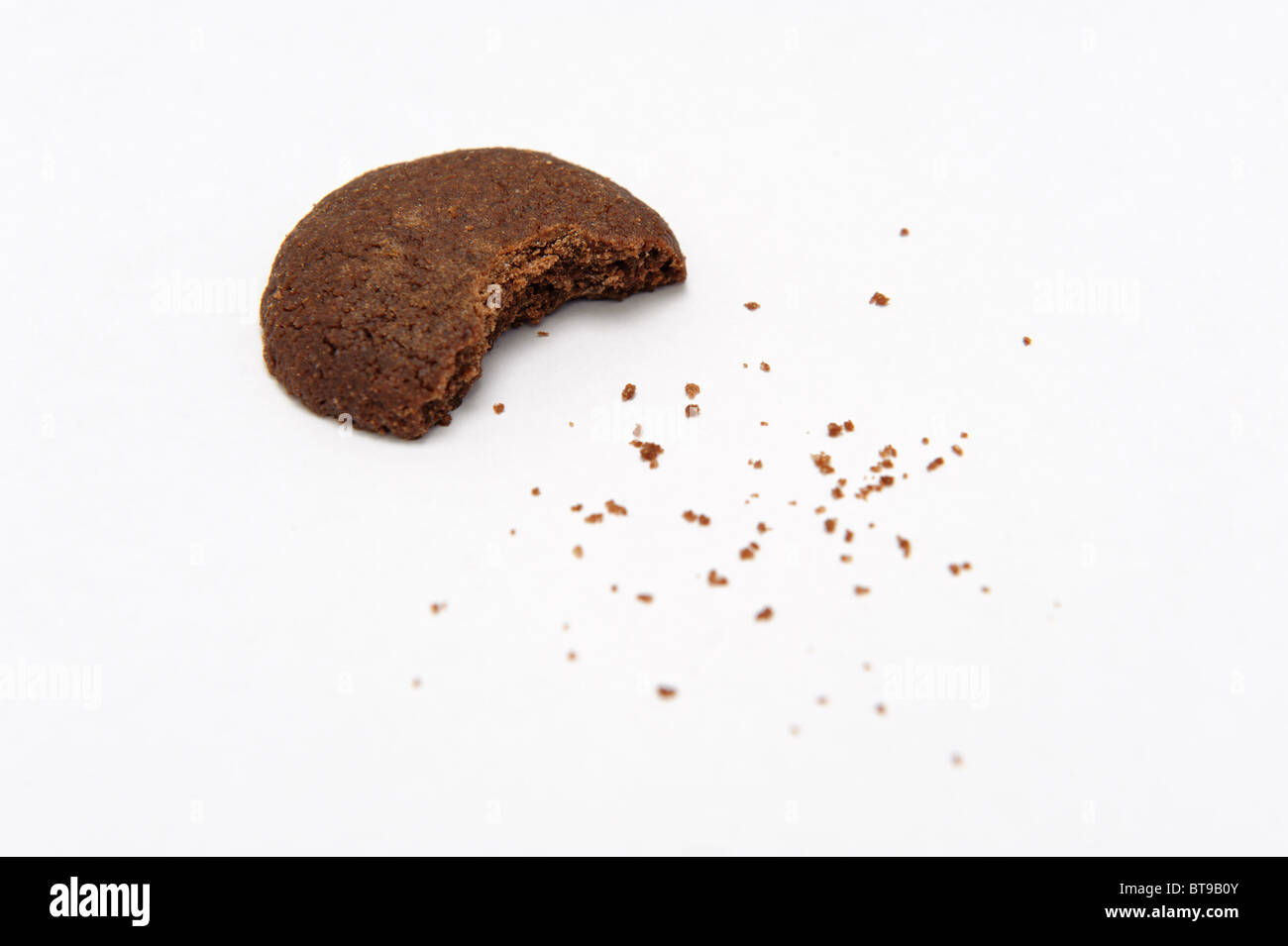 Close up of mordu chocolate cookie isolé sur fond blanc avec des miettes Banque D'Images