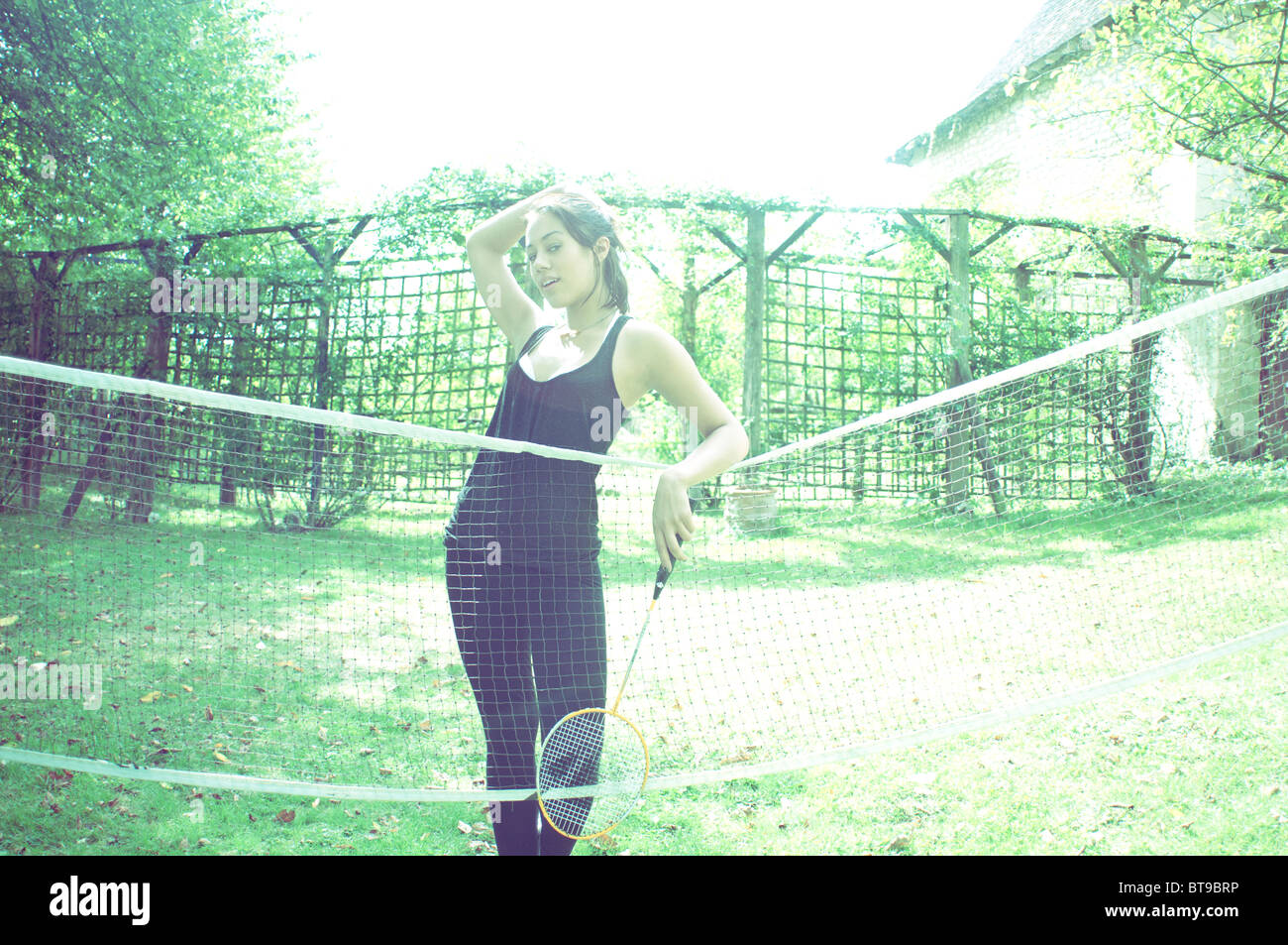 Une jeune femme debout à un filet de badminton Banque D'Images
