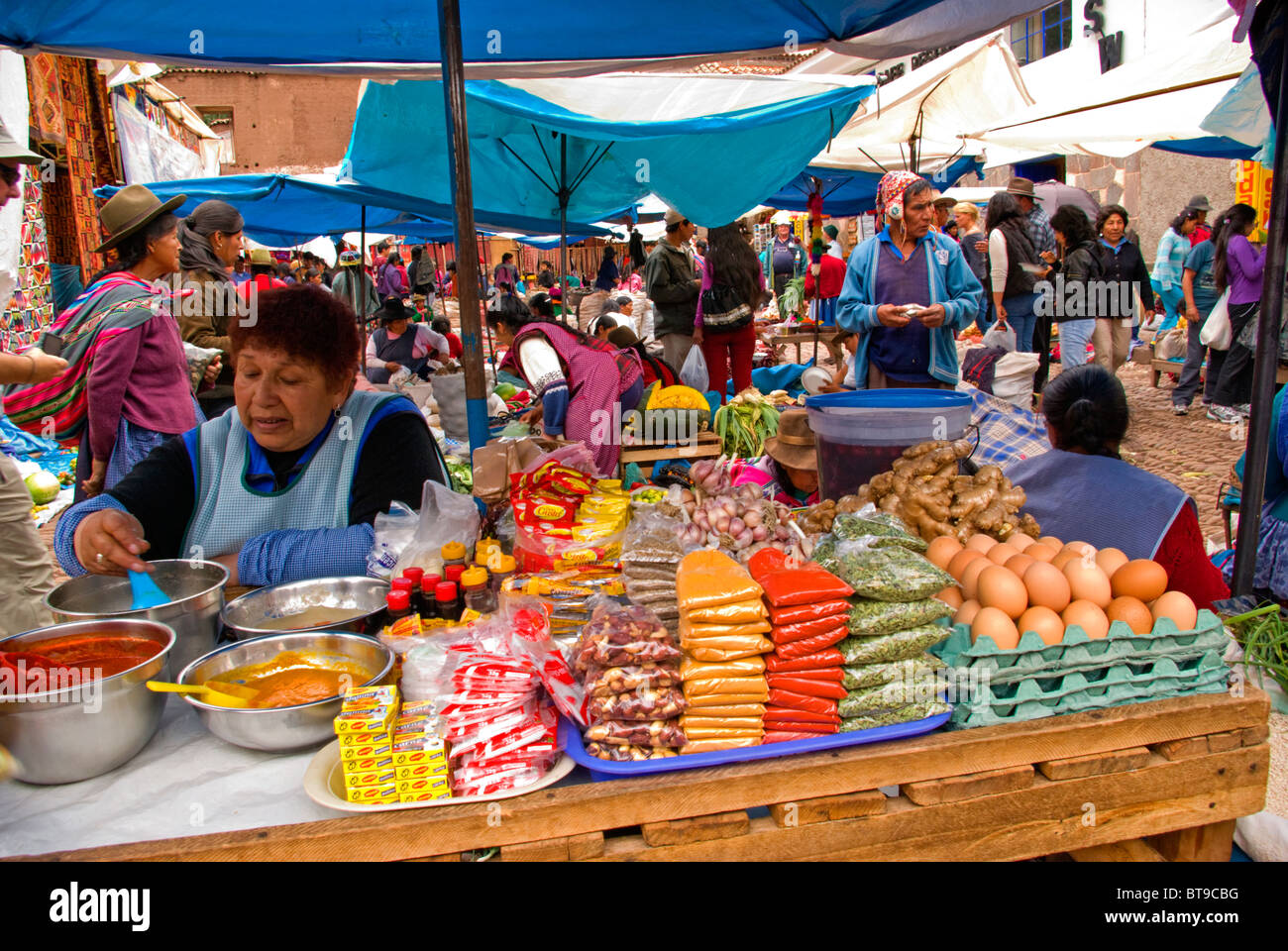 Le Pérou, la Vallée Sacrée, Pisac, marché du dimanche, les femmes s'agite bol de épices, à table avec les haricots secs, les œufs, les assaisonnements Banque D'Images