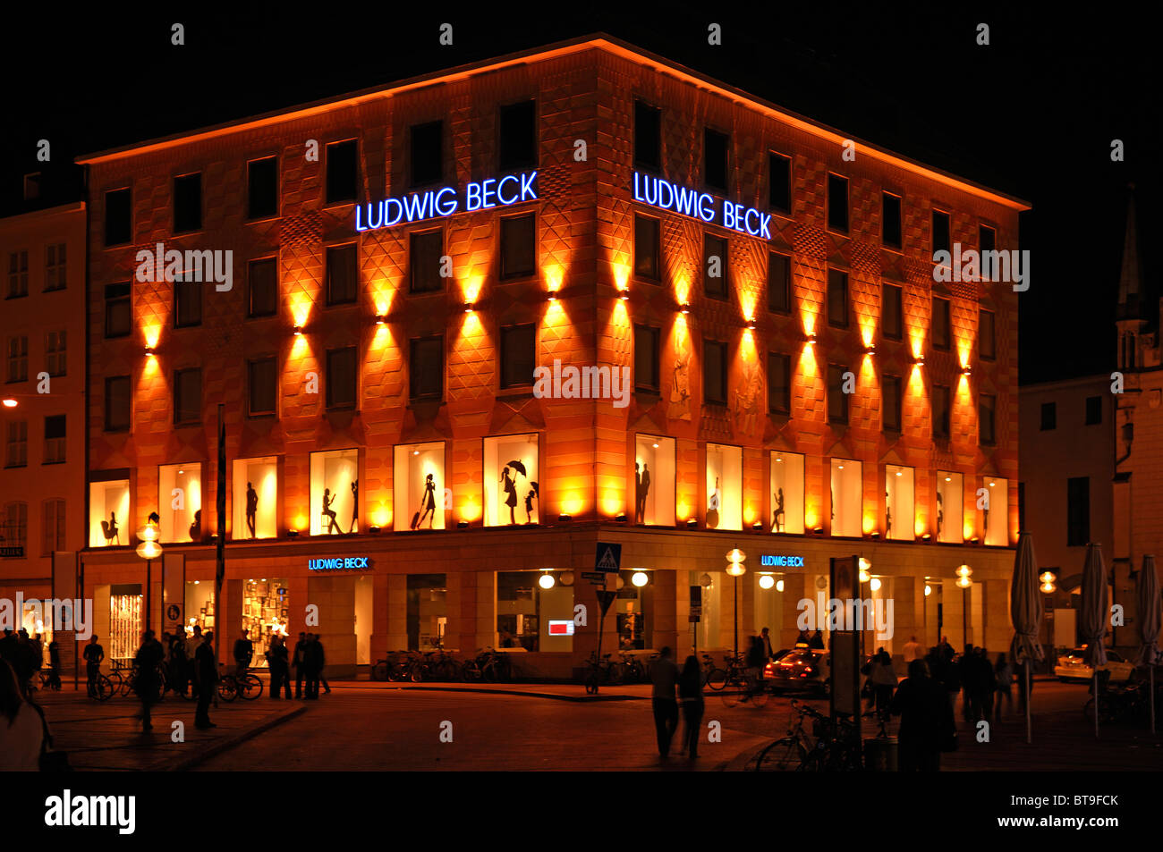 Façades d'une maison de mode illuminé la nuit, suis Marienplatz, Munich, Bavaria, Germany, Europe Banque D'Images
