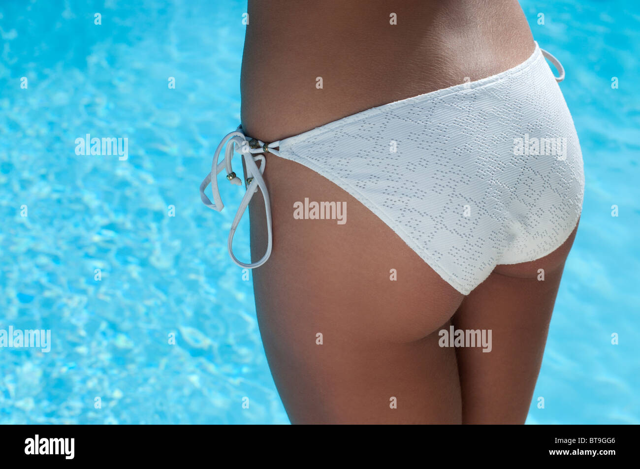 Une femme dans un bikini blanc par une piscine, vue arrière Banque D'Images