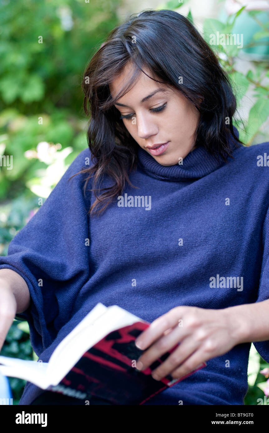 Une jeune femme lisant un livre, à l'extérieur Banque D'Images