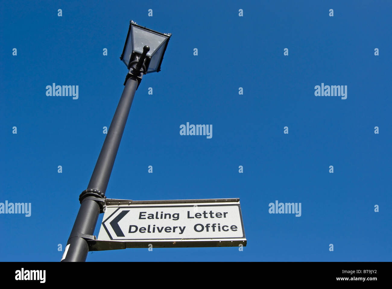 Direction d'Ealing lettre Bureau de livraison fixée à une lampe de rue, de style victorien, à Ealing, à l'ouest de Londres, Angleterre Banque D'Images