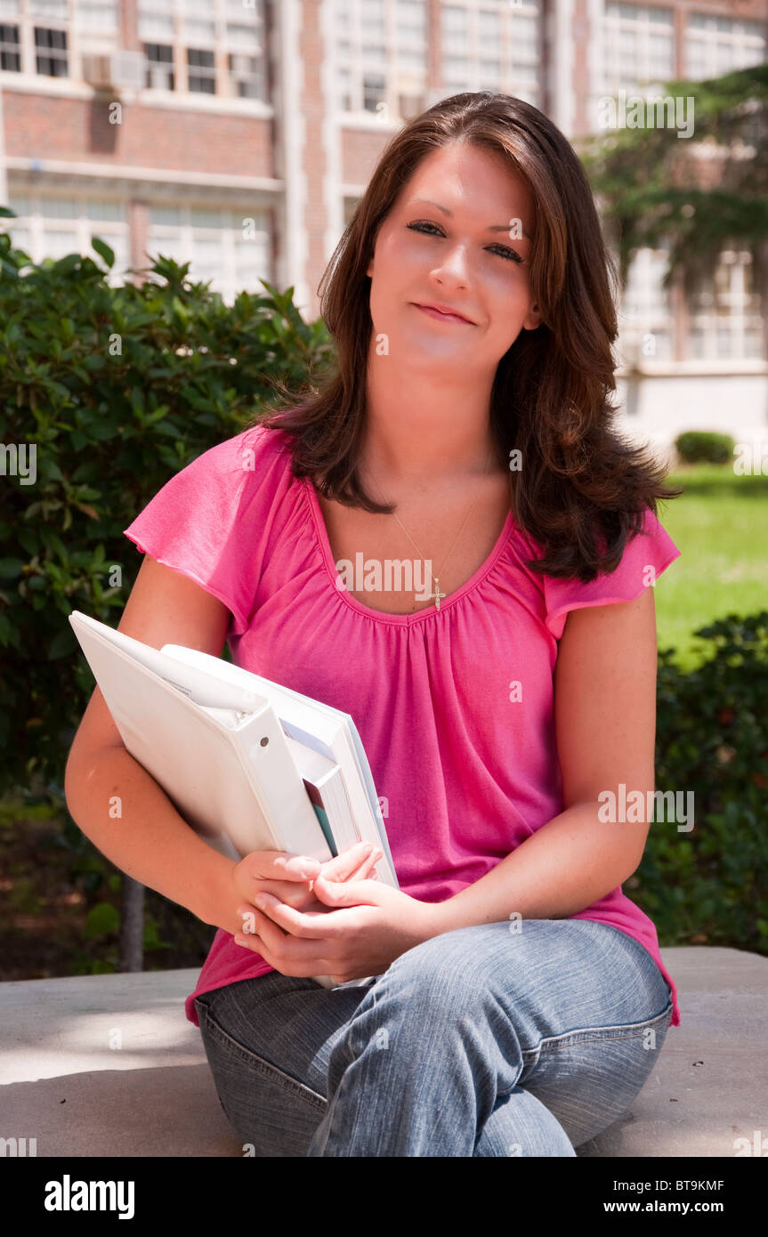 Female college student sitting avec des livres dans la main à l'école. Banque D'Images