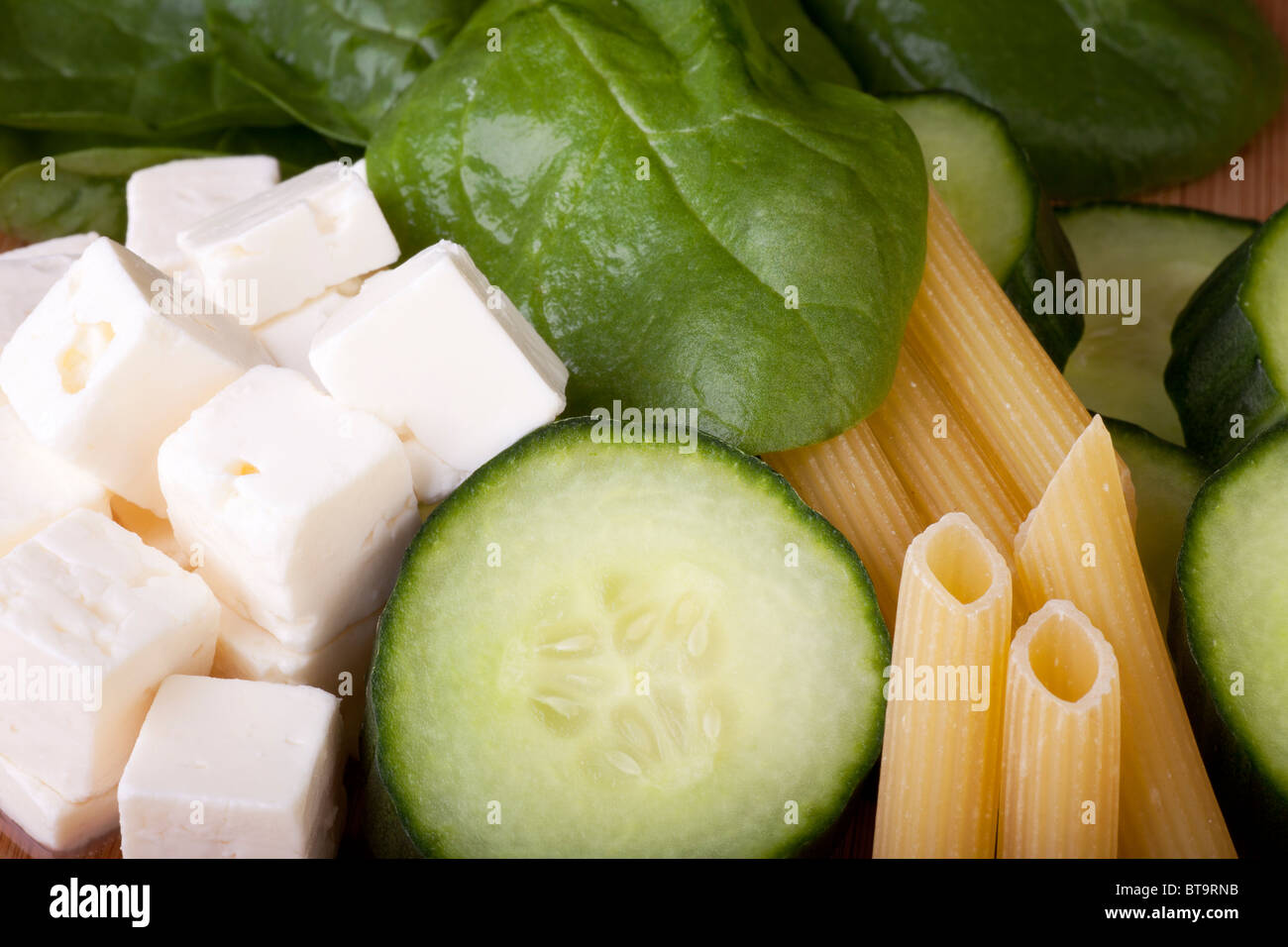 Le fromage Feta, concombre, épinard et pâtes penne prête pour une salade de pâtes Banque D'Images