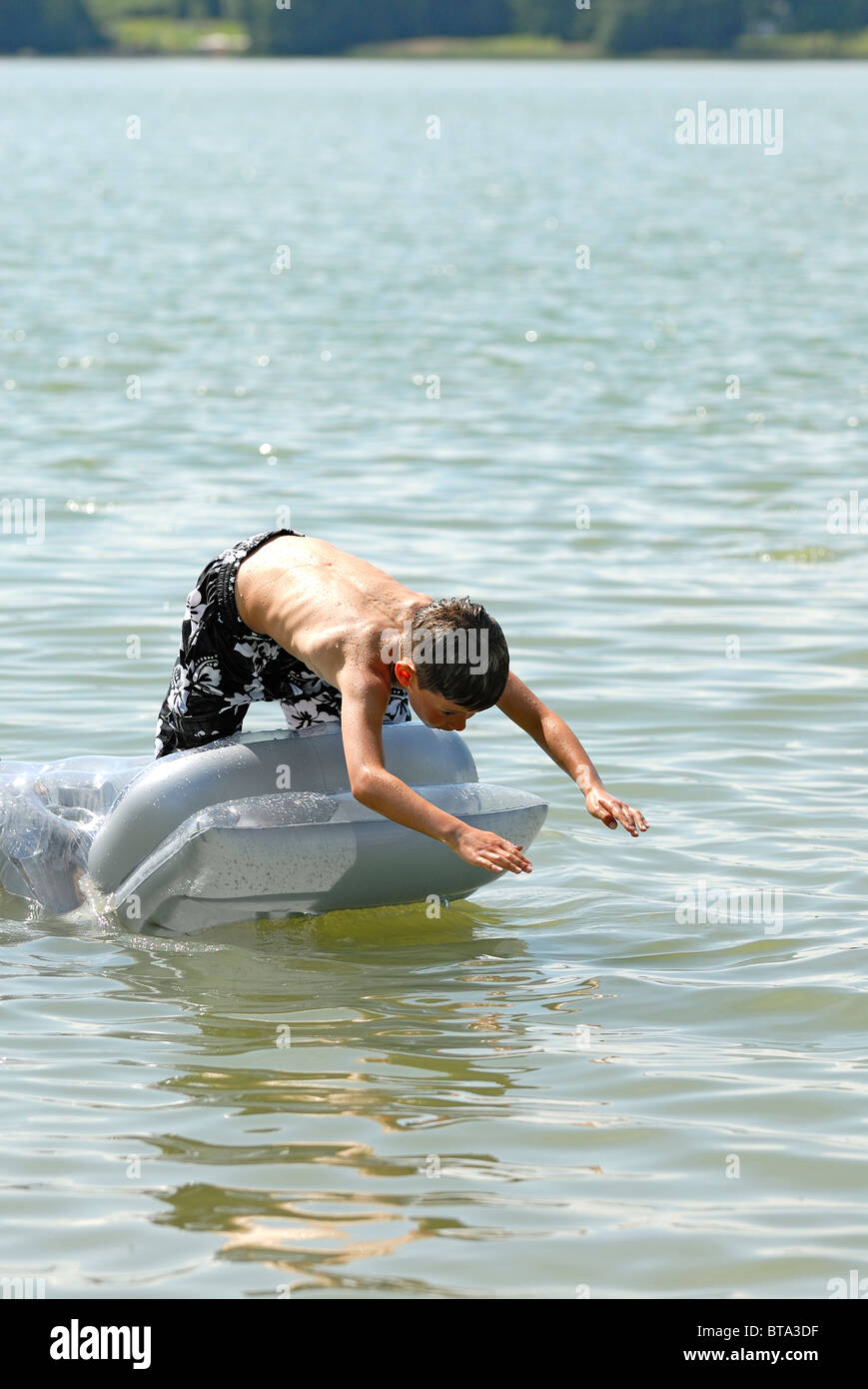 Garçon sautant dans l'eau Banque D'Images