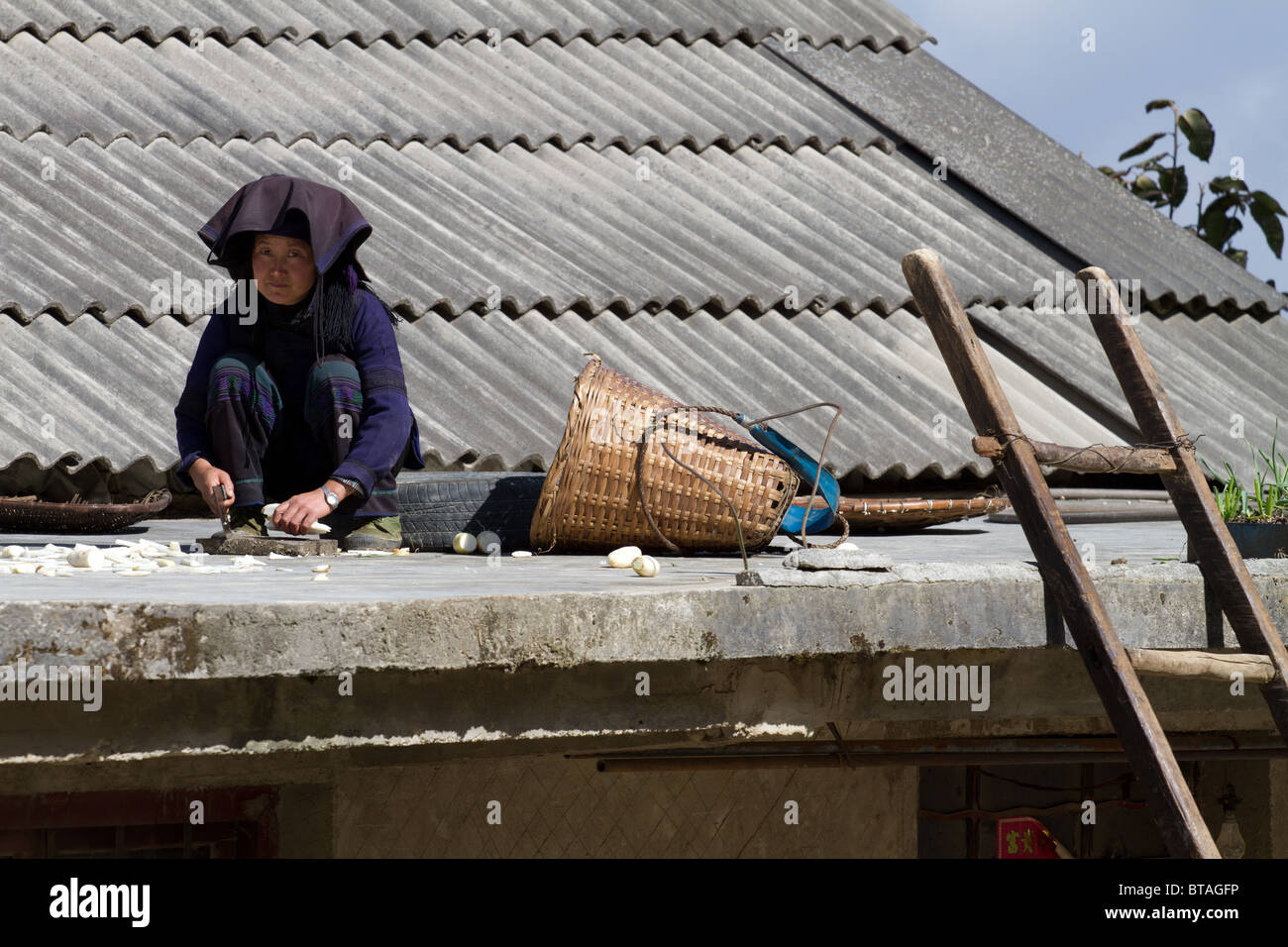 Une minorité de femme assise sur son toit tout en réduisant l'prouce Banque D'Images