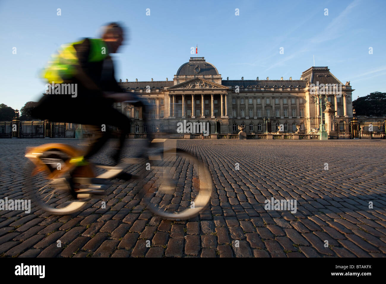 Un homme monte un vélo à côté du Palais Royal à Bruxelles Banque D'Images