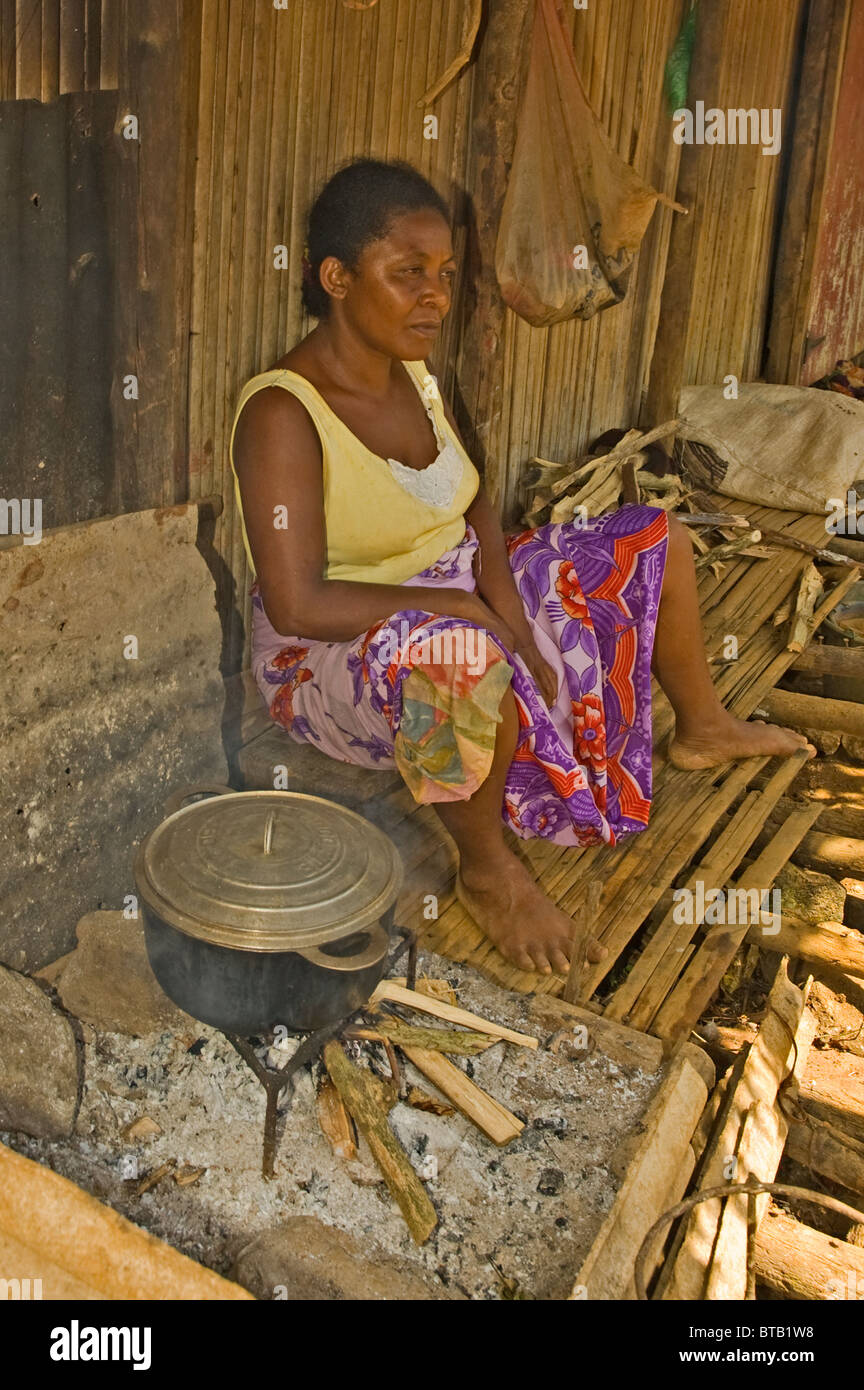 Afrique Madagascar Nosy Be woman cooking avec un pot et le feu devant sa maison Banque D'Images