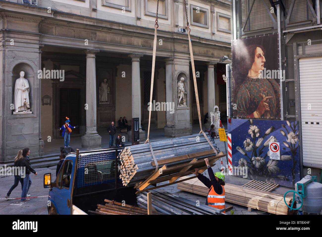 Ouvrier de construction et les touristes sous l'art de la renaissance de Florence de l'affiche de la Piazza degli Uffizi. Banque D'Images