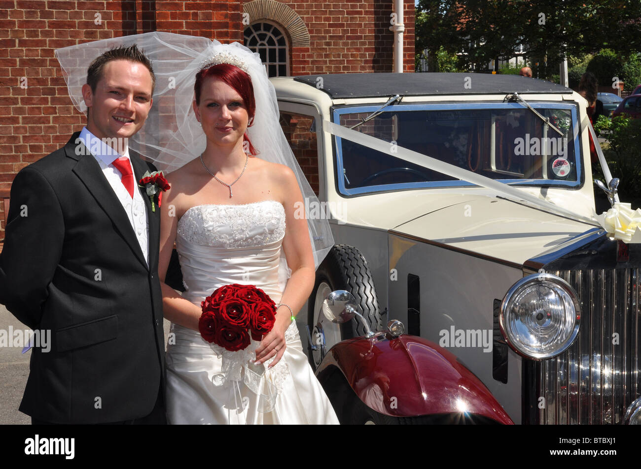 Mariée et le marié avec voiture de mariage Banque D'Images