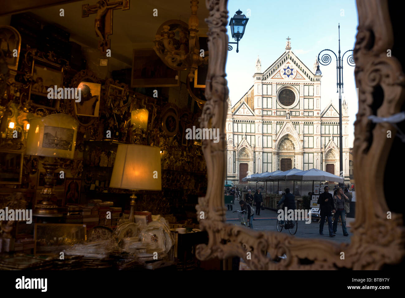 Des icônes religieuses et de souvenirs avec l'église de Santa Croce reflétée dans le miroir à la fin de la Piazza. Banque D'Images
