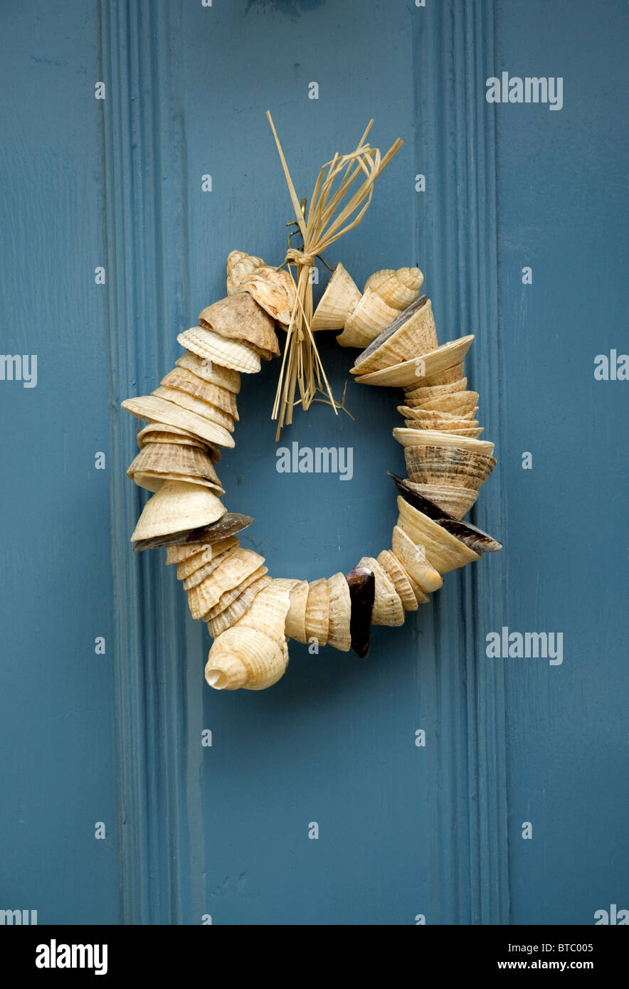 Sea Shell décoration guirlande accrochée à un porte en bois bleu Banque D'Images
