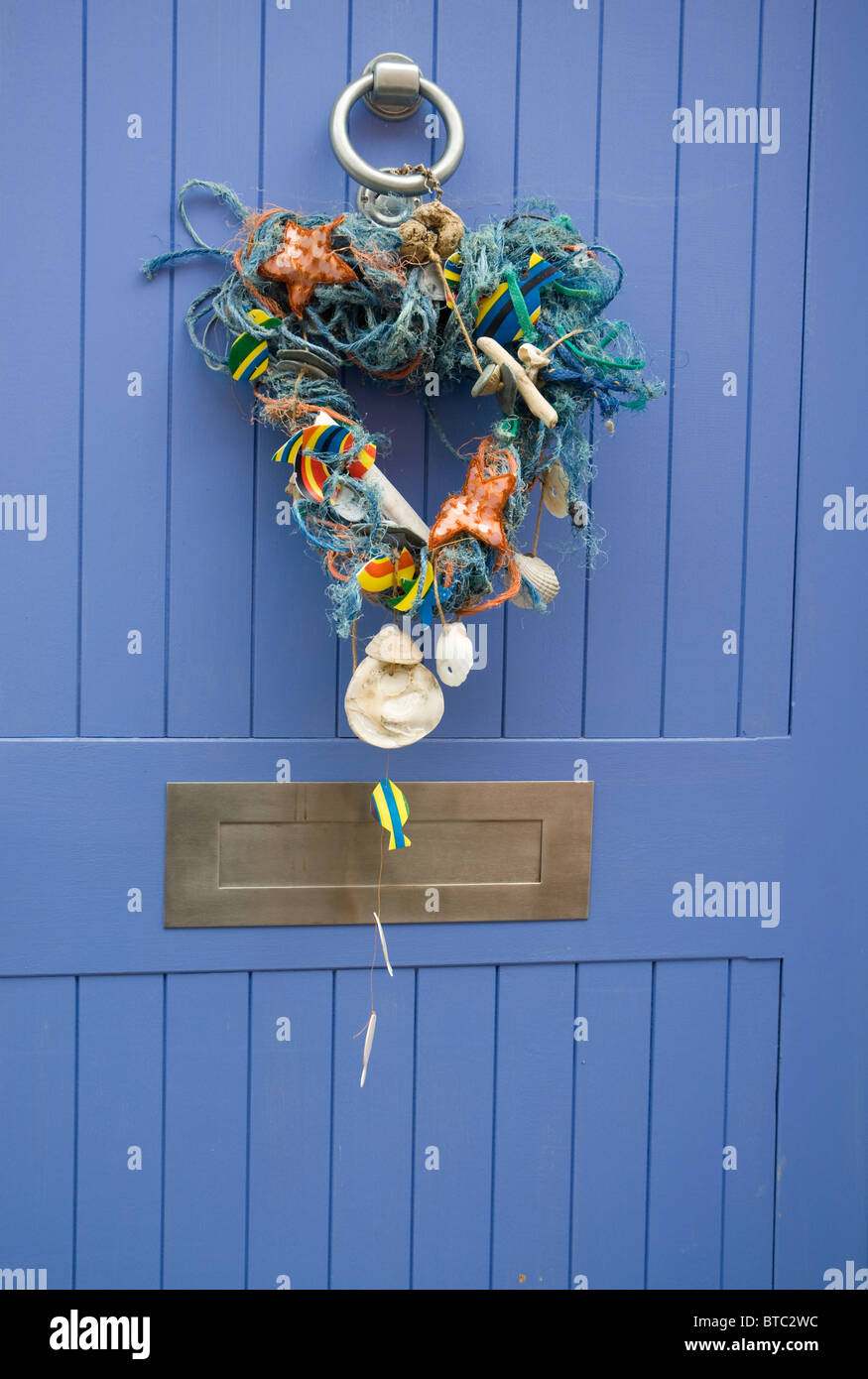 Bois flotté, coquillages et corde décoration sur une porte bleue Banque D'Images