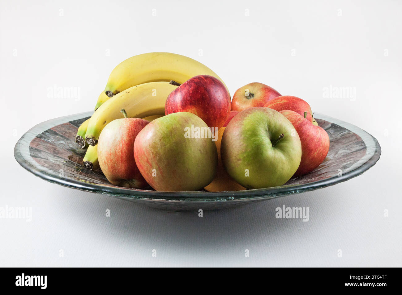 La vie encore tourné d'un bol de fruits dans un plat en verre décoré Banque D'Images