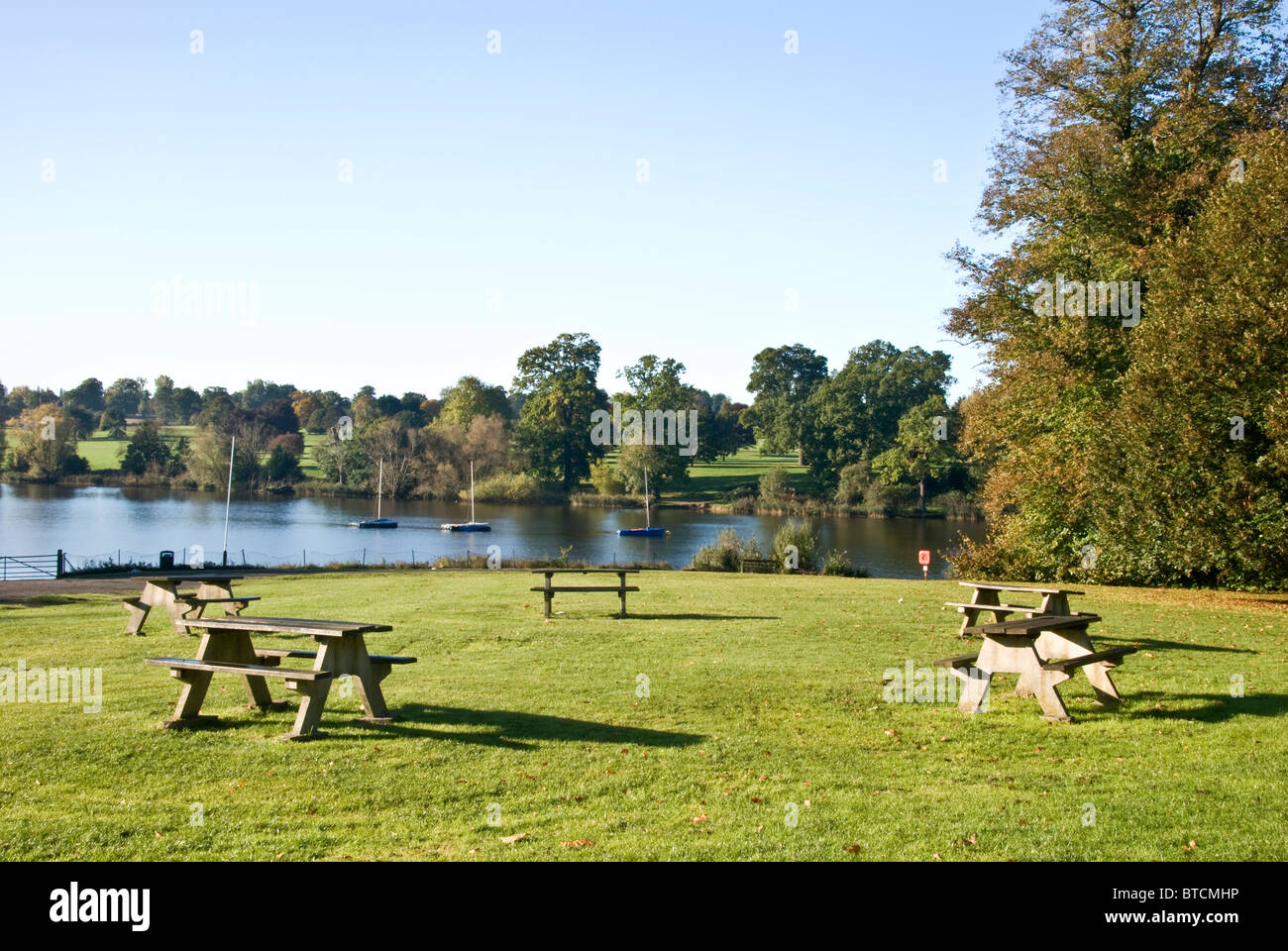 Tableaux des bancs de pique-nique au bord d'un lac Banque D'Images
