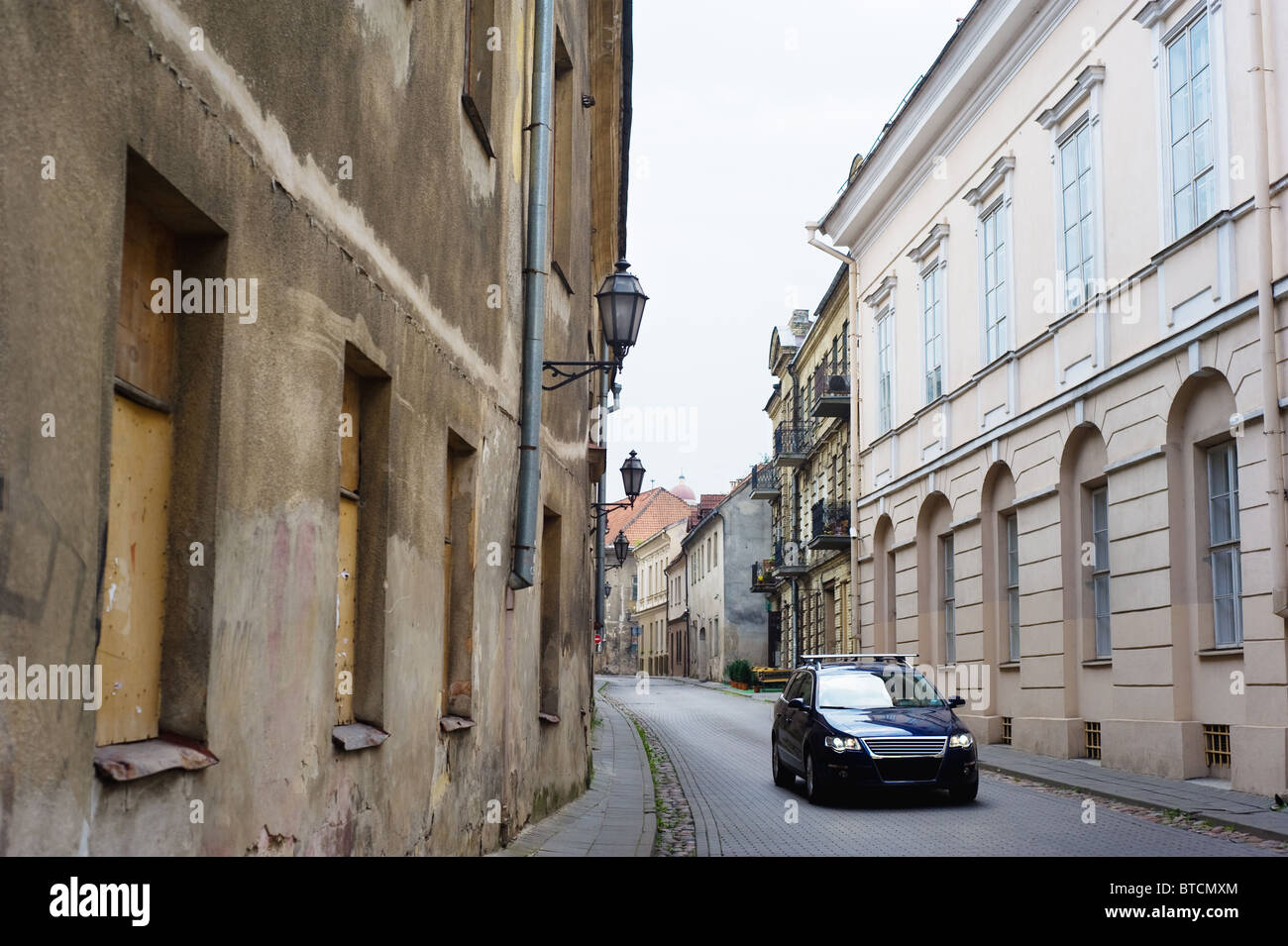 Voiture moderne dans la rue étroite pavée de la vieille ville de Vilnius Banque D'Images