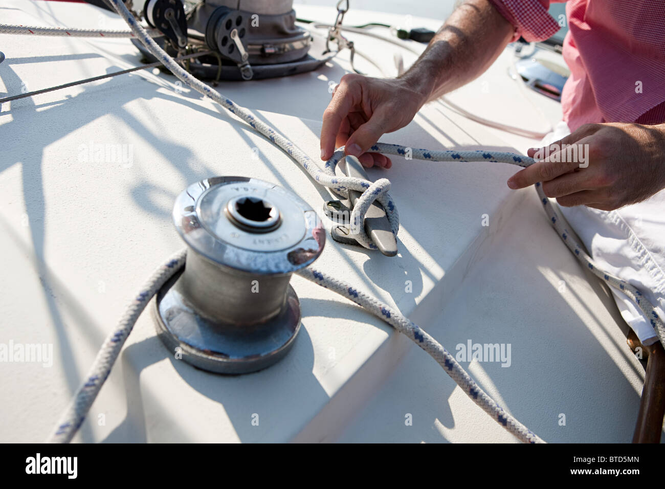 Mid adult man on yacht conseil holding rope Banque D'Images