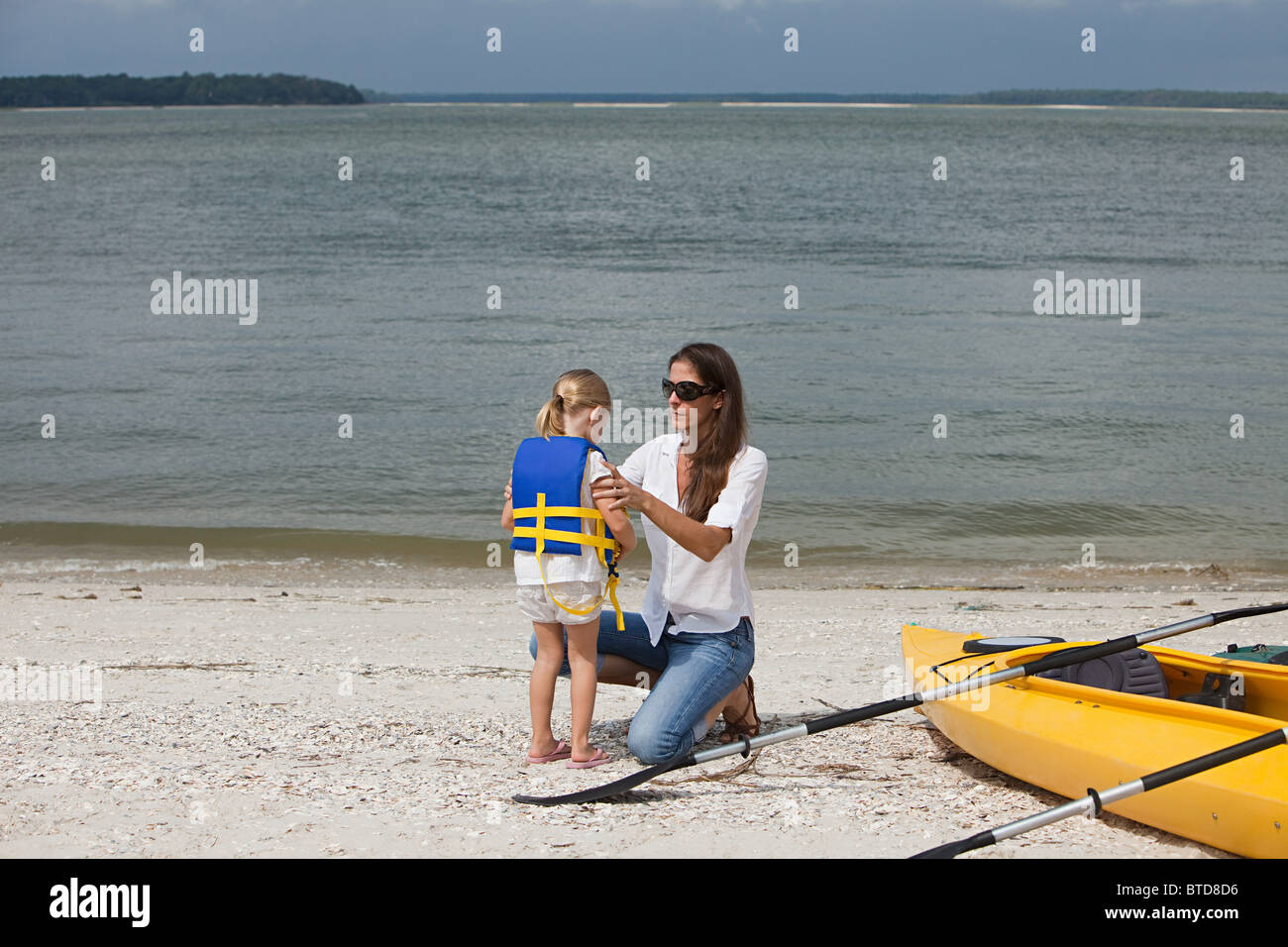 Mother putting gilet sur fille pour kayak Banque D'Images