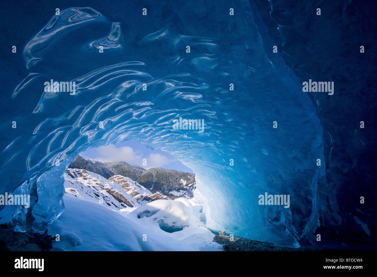 Vue depuis l'intérieur d'une grotte de glace à l'extérieur à la neige paysage, Mendenhall Glacier près de Juneau en Alaska, Winter Banque D'Images