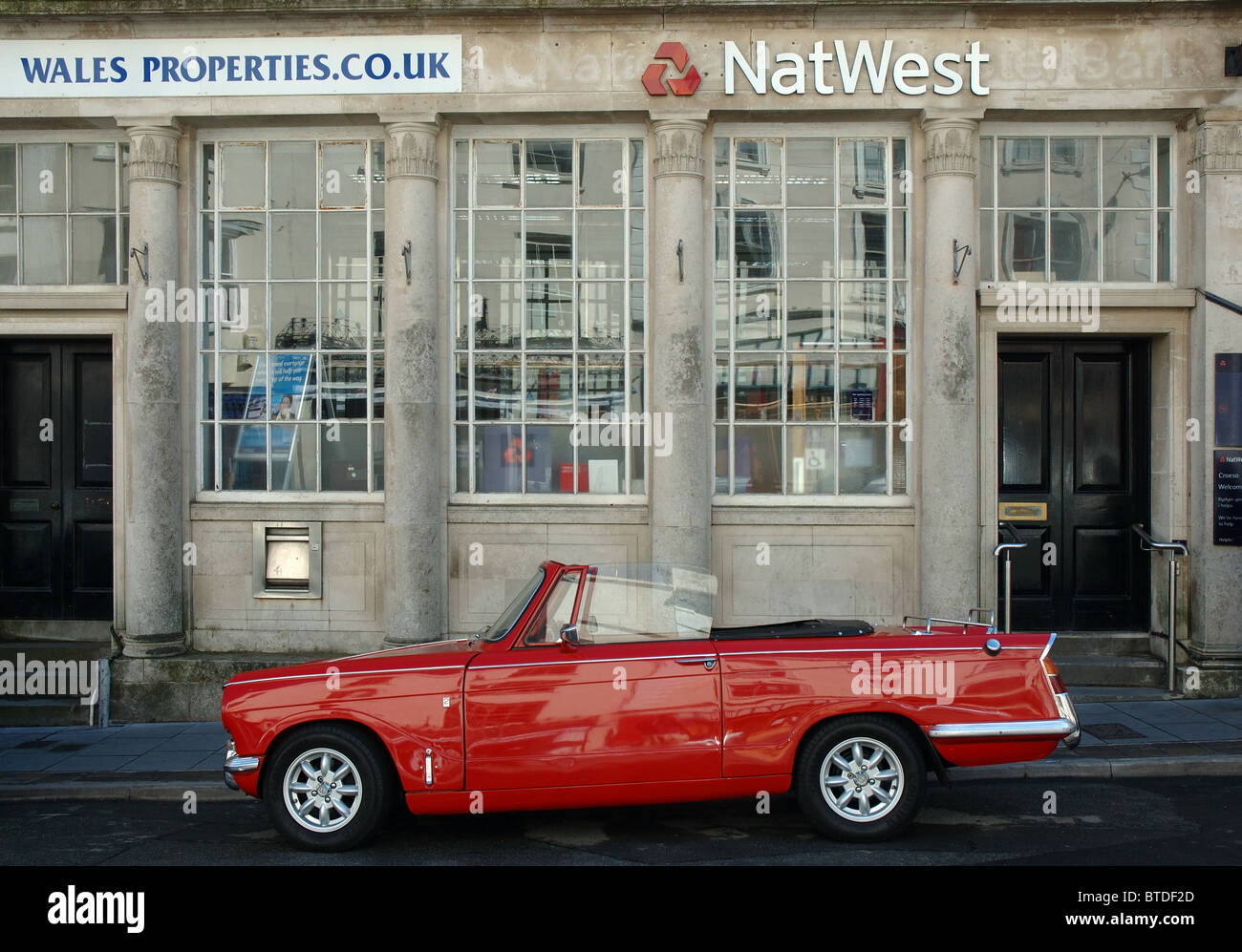Sportscar rouge à l'extérieur de la Banque Natwest, Tenby, Pays de Galles, Royaume-Uni Banque D'Images