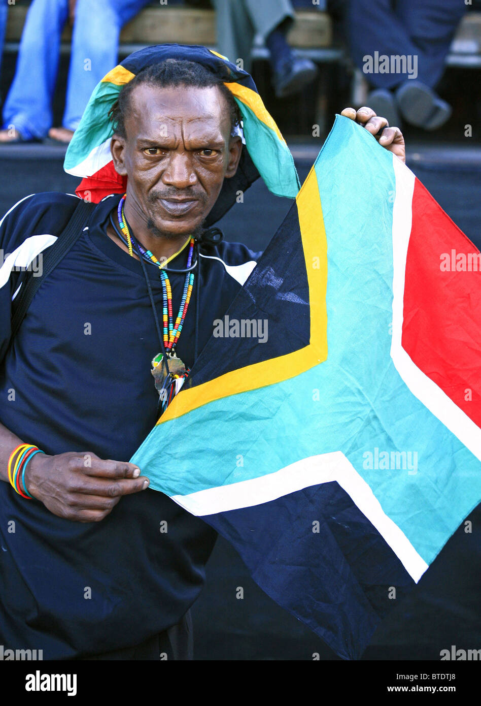 Supporter de football sud-africain tient le drapeau sud-africain pendant la Coupe du Monde 2010 Banque D'Images