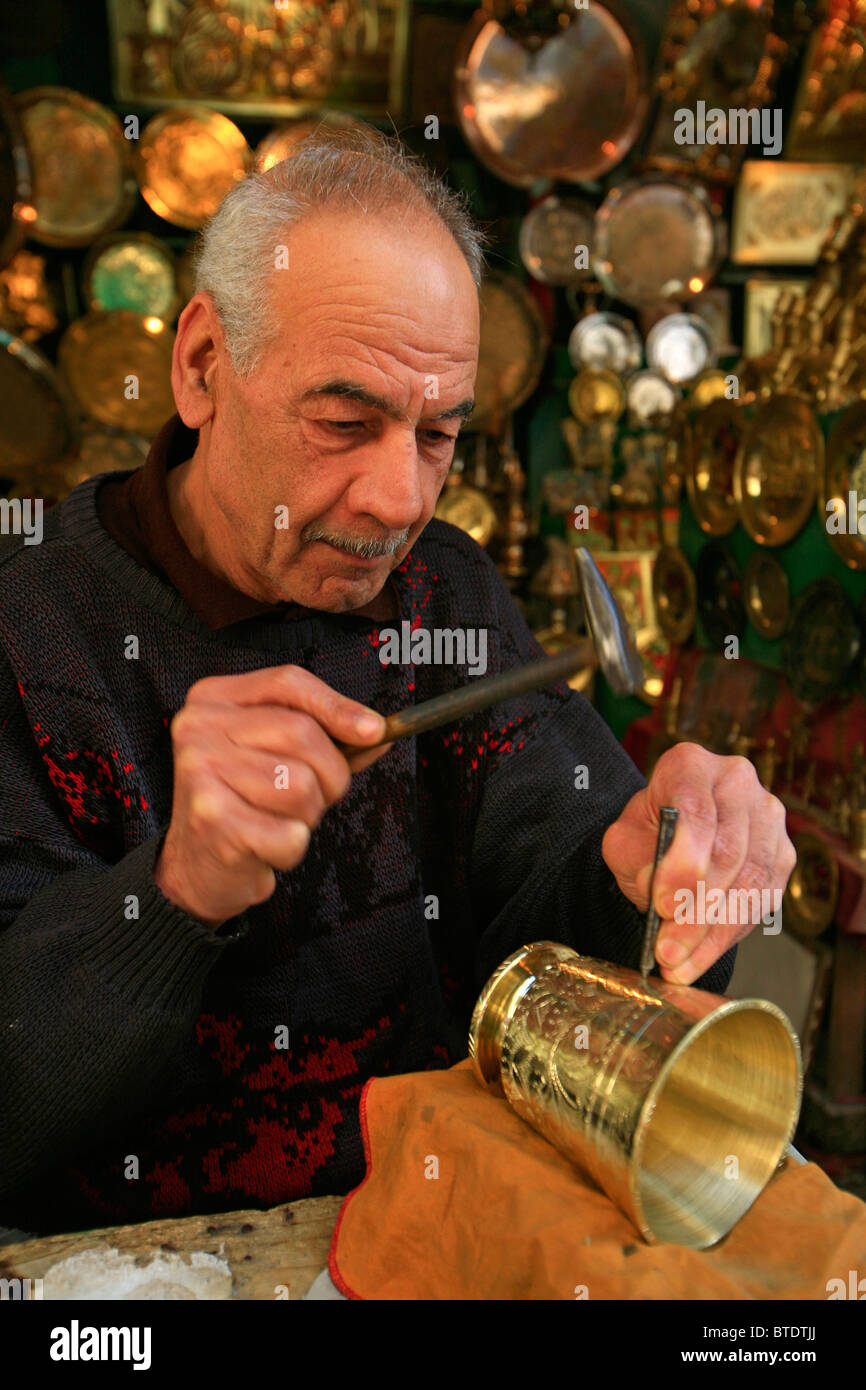 Un Artisan au travail carving modes sur une coupe en laiton dans la médina de Tunis Banque D'Images