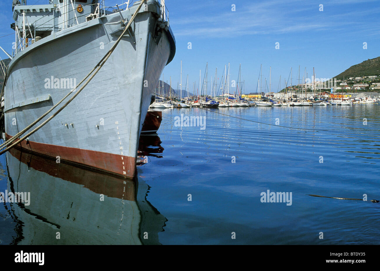 Chalutier à Hout Bay Harbour avec grand nombre de bateaux et yachts amarrés dans l'arrière-plan Banque D'Images