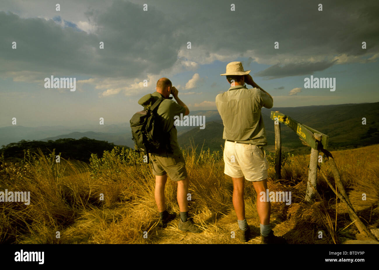 Les randonneurs à la recherche dans les jumelles à viewpoint sur Nyika plateau Banque D'Images