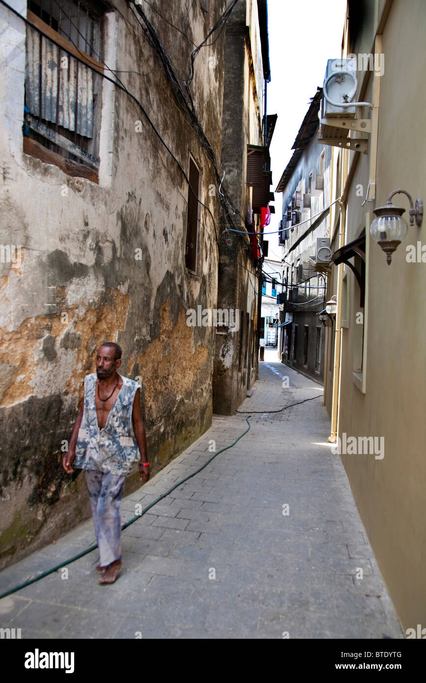 Homme marchant le long d'une ruelle de Stonetown Banque D'Images