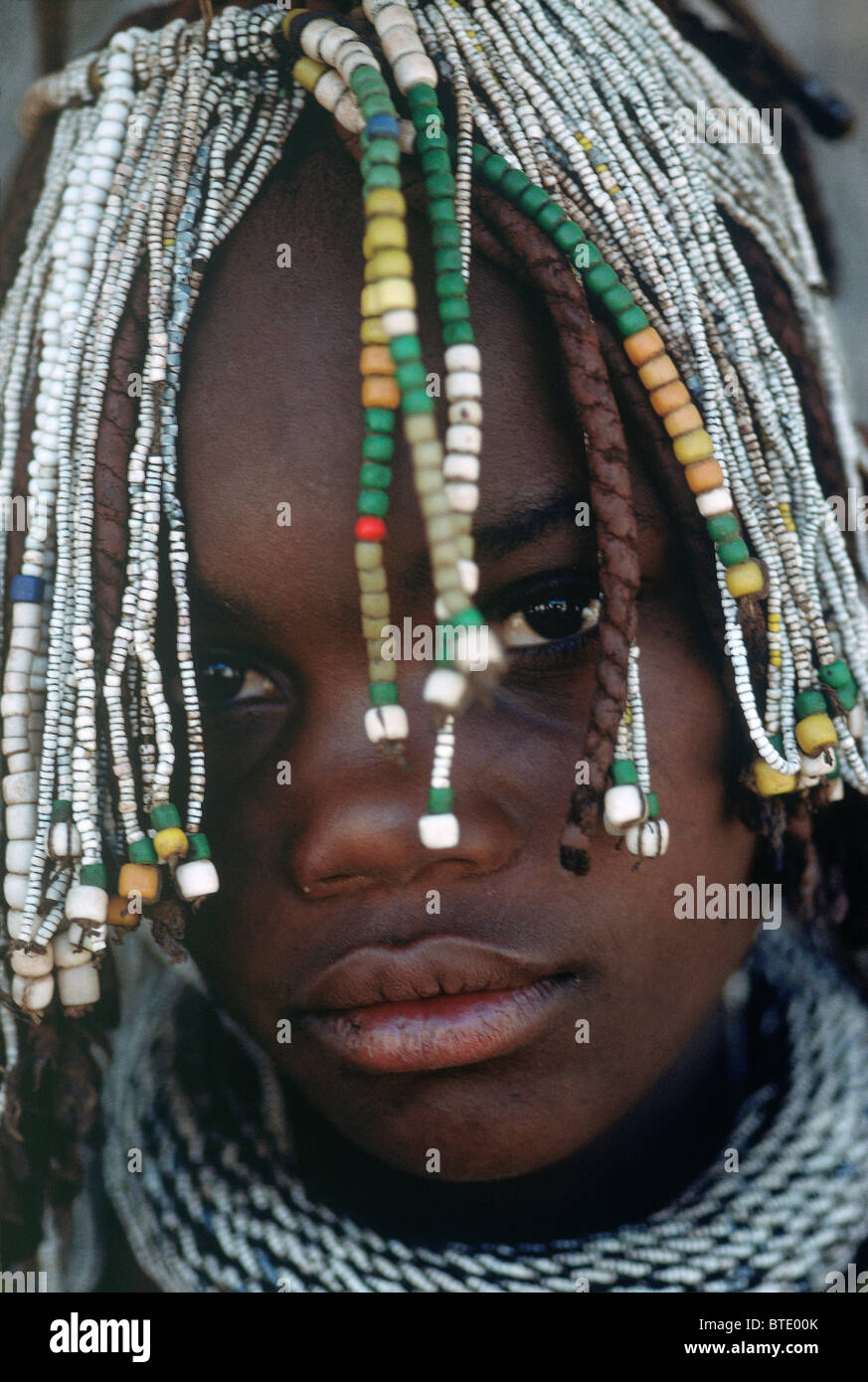 Le portrait d'une jeune fille Himba avec perles traditionnelles dans ses cheveux tressés Banque D'Images
