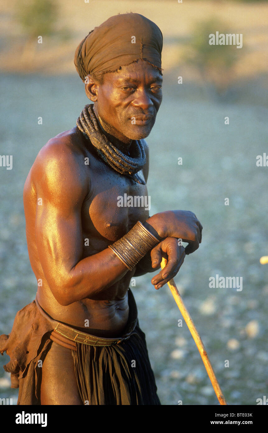 Himba homme habillé en costume traditionnel s'appuyant sur un bâton de marche Banque D'Images