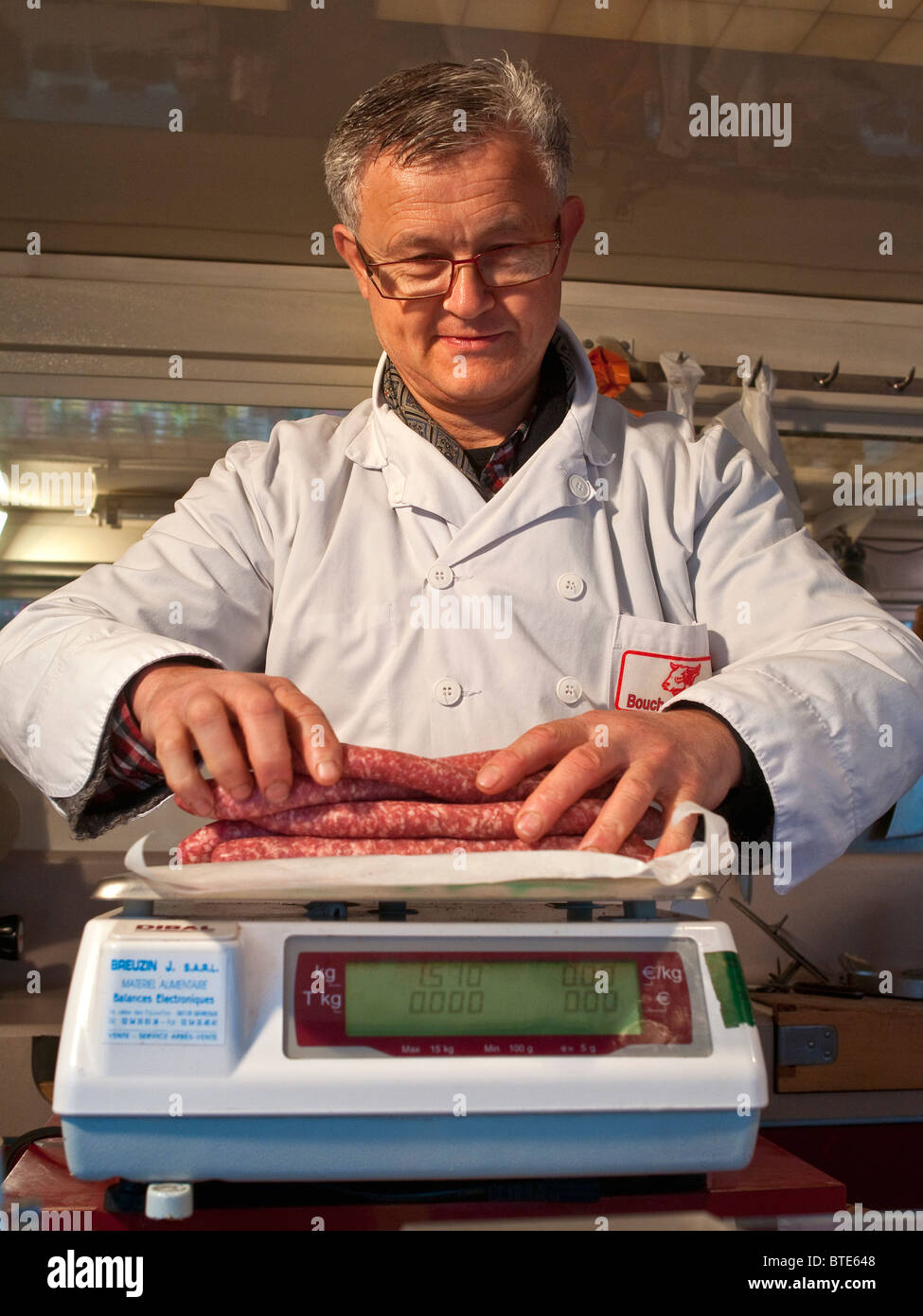 Butcher pesant des saucisses de porc - France. Banque D'Images