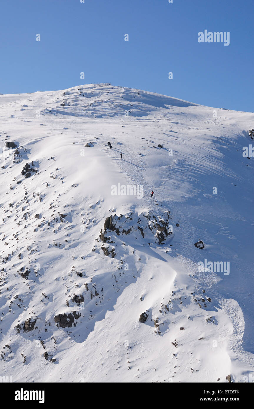 Les marcheurs approcher le sommet de Scafell Pike en hiver dans le Lake District Banque D'Images