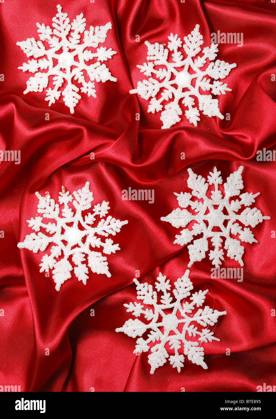 Décoration de Noël sur satin de rouge avec de gros flocons Banque D'Images