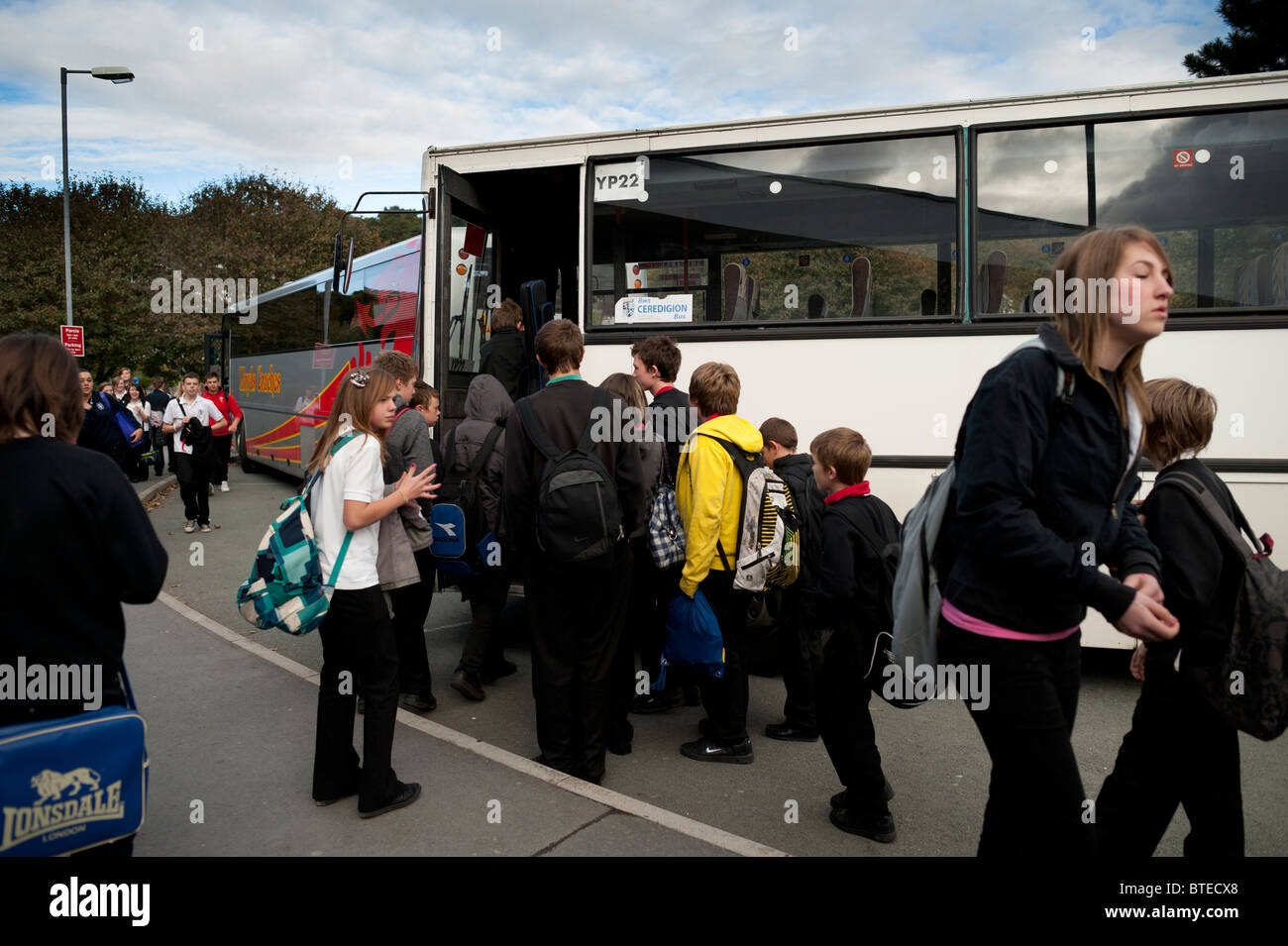 Élèves du secondaire de prendre le bus à la maison à la fin de la journée scolaire, UK Banque D'Images